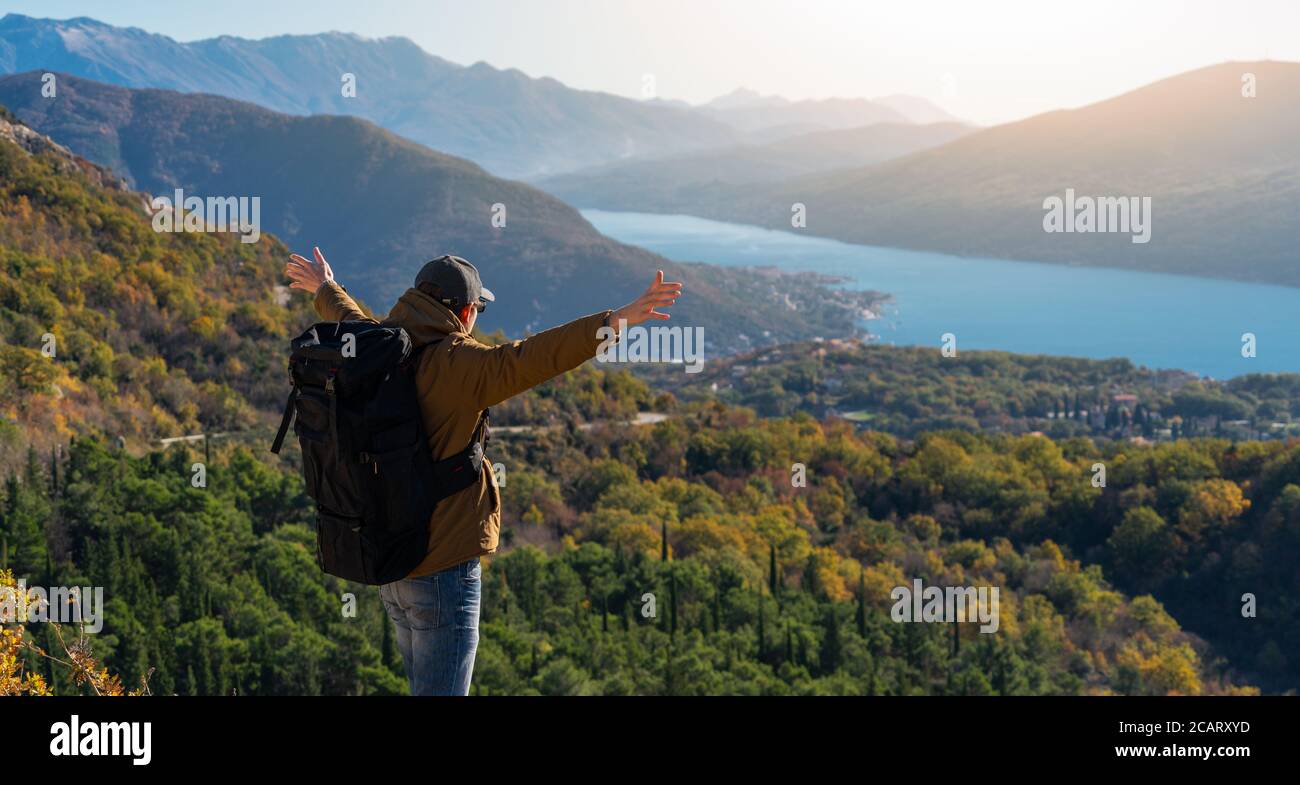 Un voyageur avec un sac à dos se tient sur le dessus de la montagne Banque D'Images