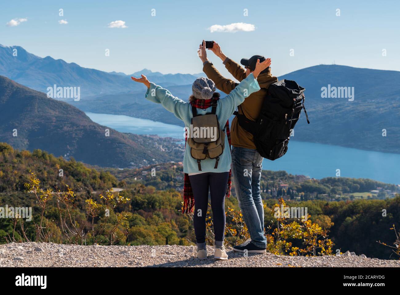 Un couple de voyageurs avec un smartphone au sommet d'une montagne. Banque D'Images