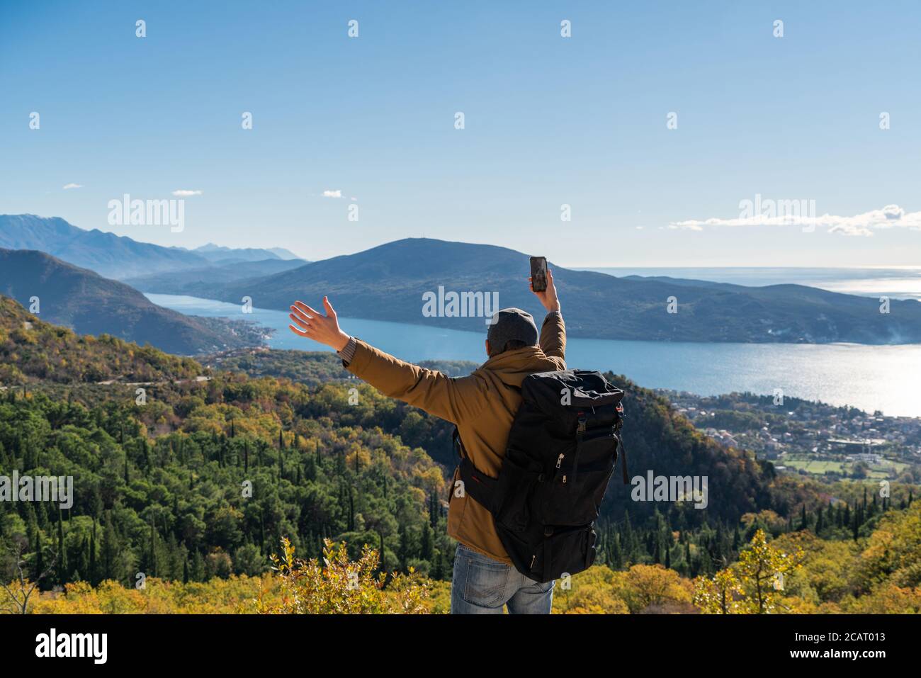 Voyageur avec un sac à dos et un smartphone se tient sur un montagne Banque D'Images