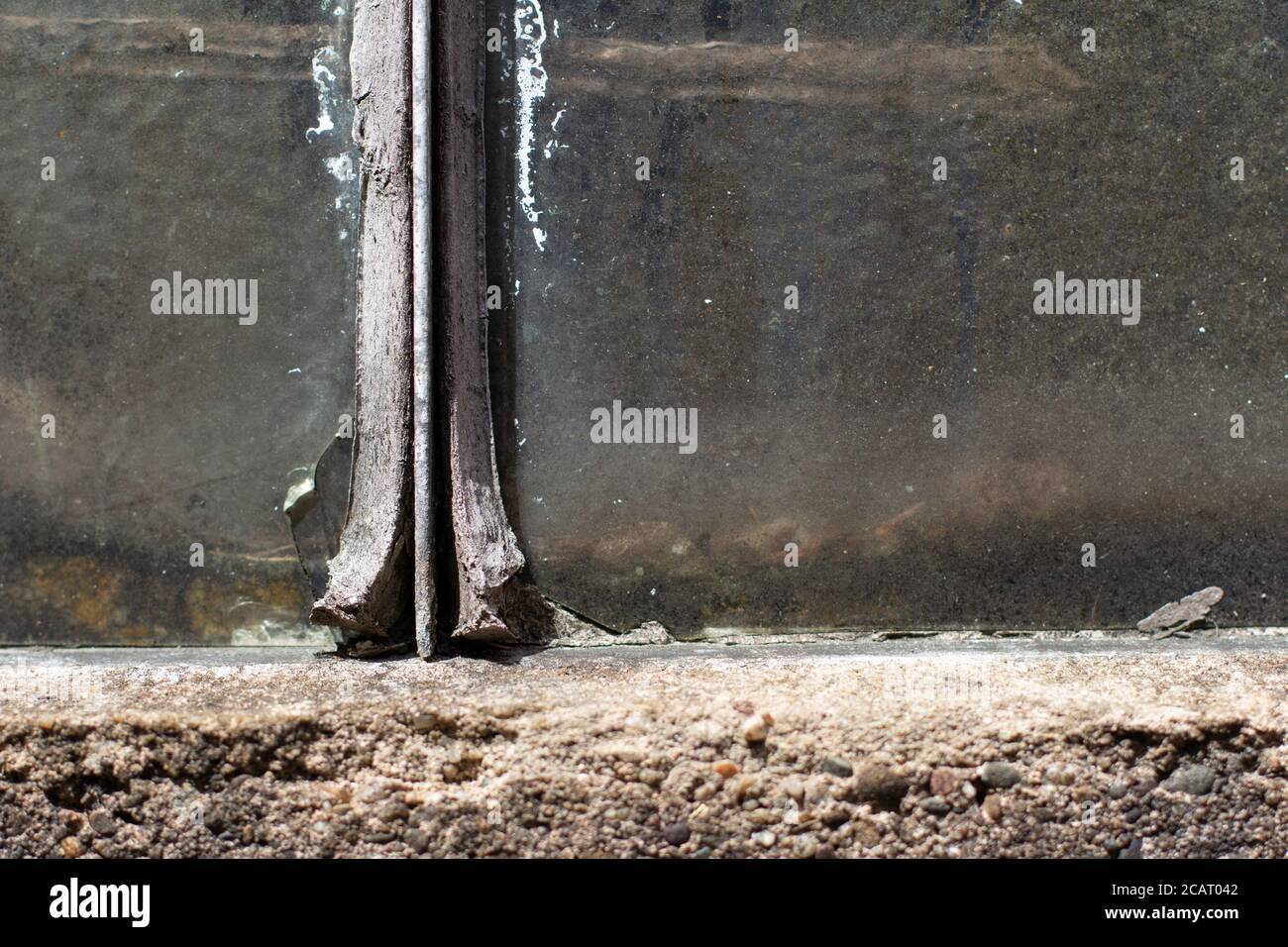 Joint de vitre vieux, sec et fissuré qui s'écaille entre la vitre et le cadre métallique Banque D'Images