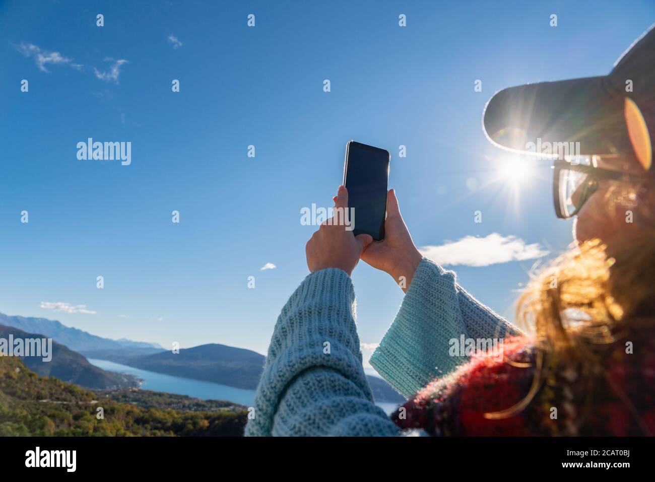 Voyageur avec un sac à dos et un smartphone se tient sur un montagne Banque D'Images