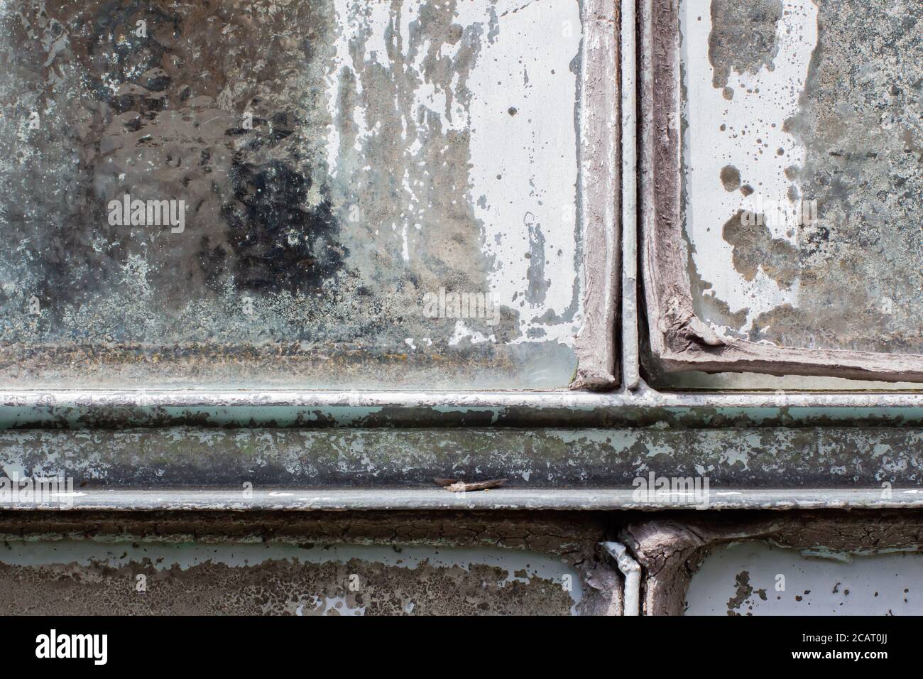 Joint de vitre vieux, sec et fissuré qui s'écaille entre la vitre et le cadre métallique Banque D'Images