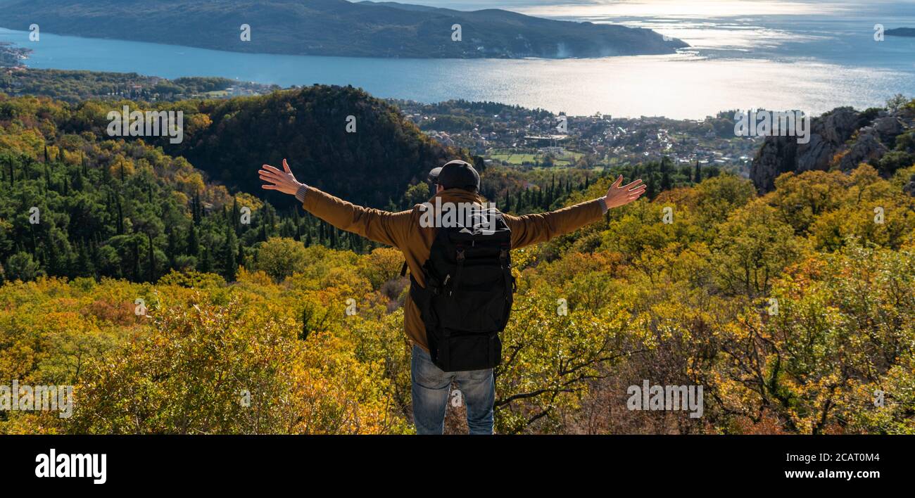Un voyageur avec un sac à dos se tient sur le dessus de la montagne Banque D'Images