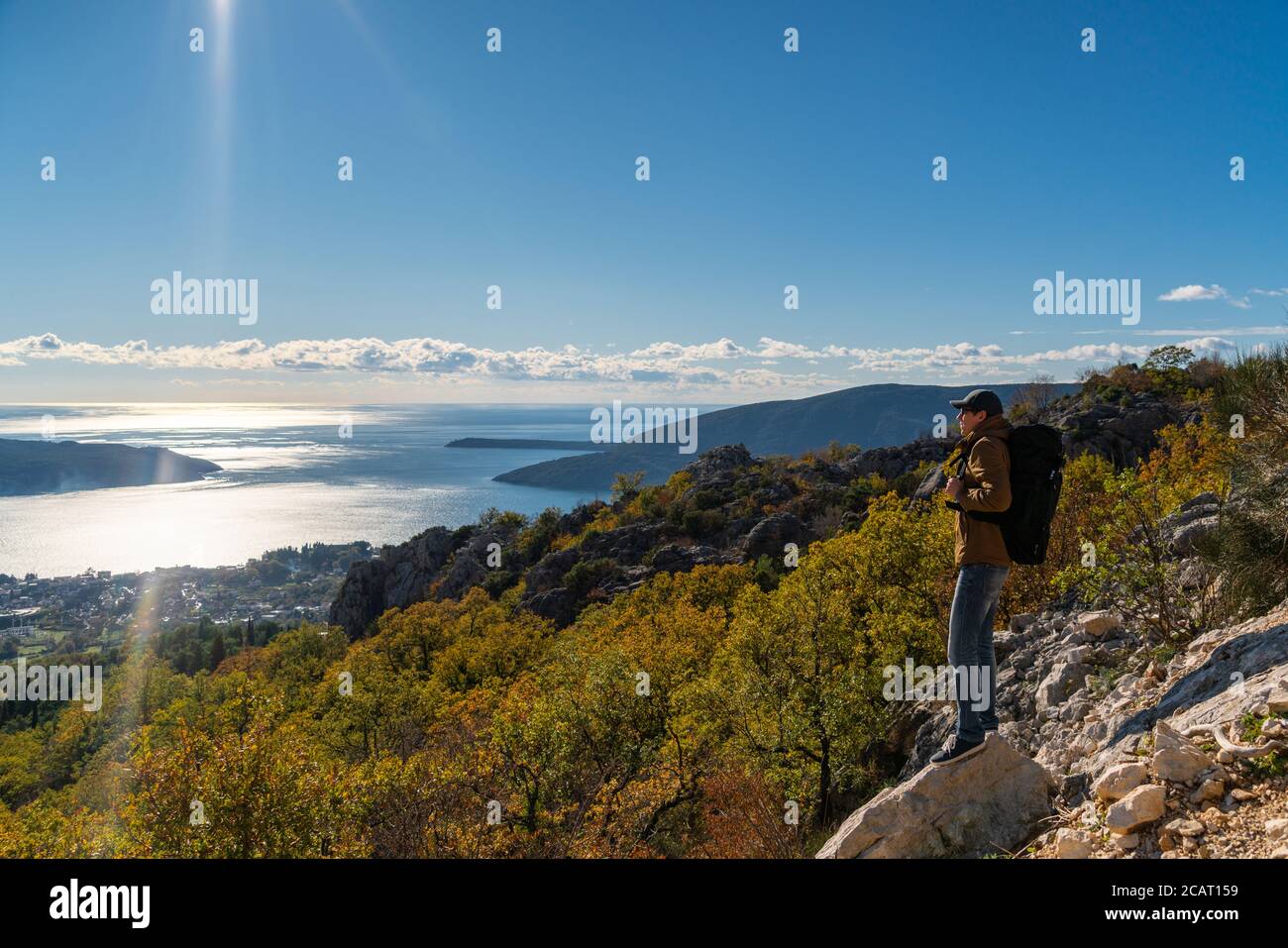 Un voyageur avec un sac à dos se tient sur le dessus de la montagne Banque D'Images