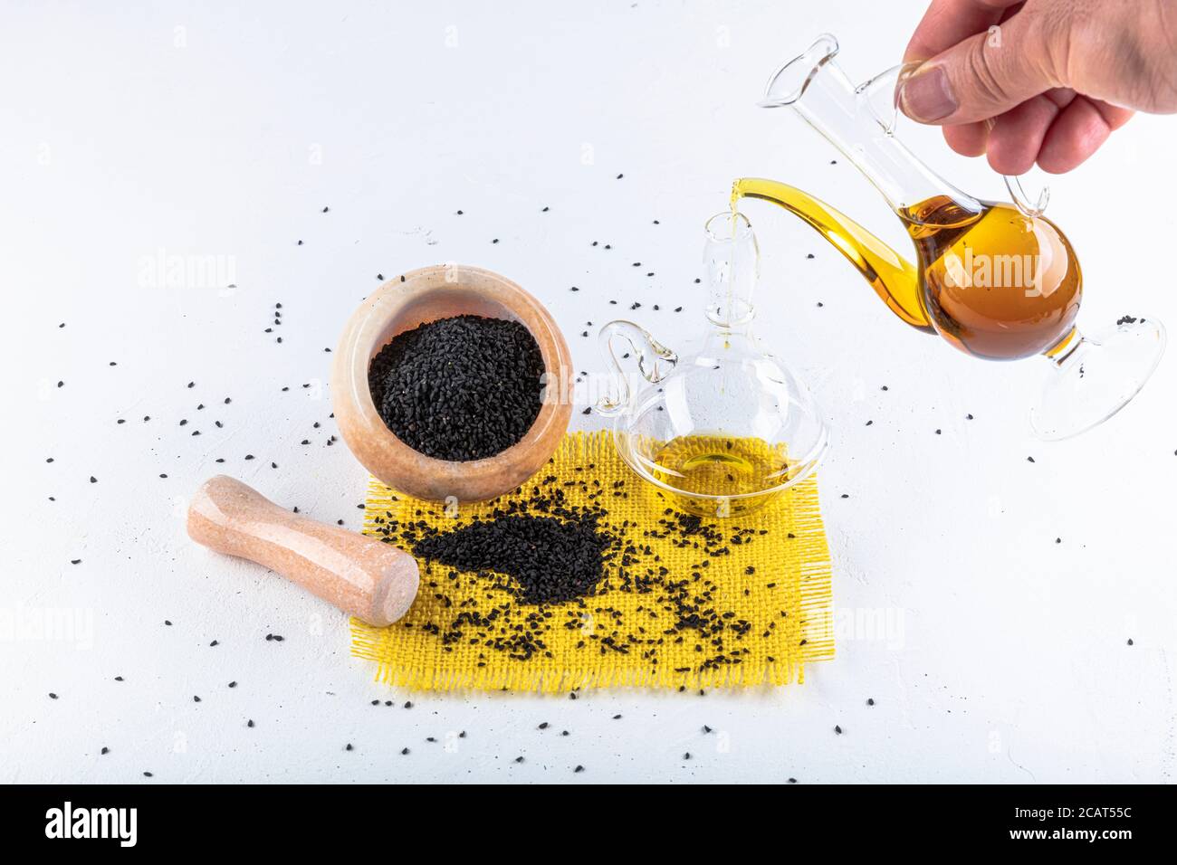 Graines de cumin noires et huile essentielle avec bol et pelle ou cuillère en bois. Nigella Sativa en bouteille de verre. La médecine biologique à base de plantes pour de nombreuses maladies. Banque D'Images