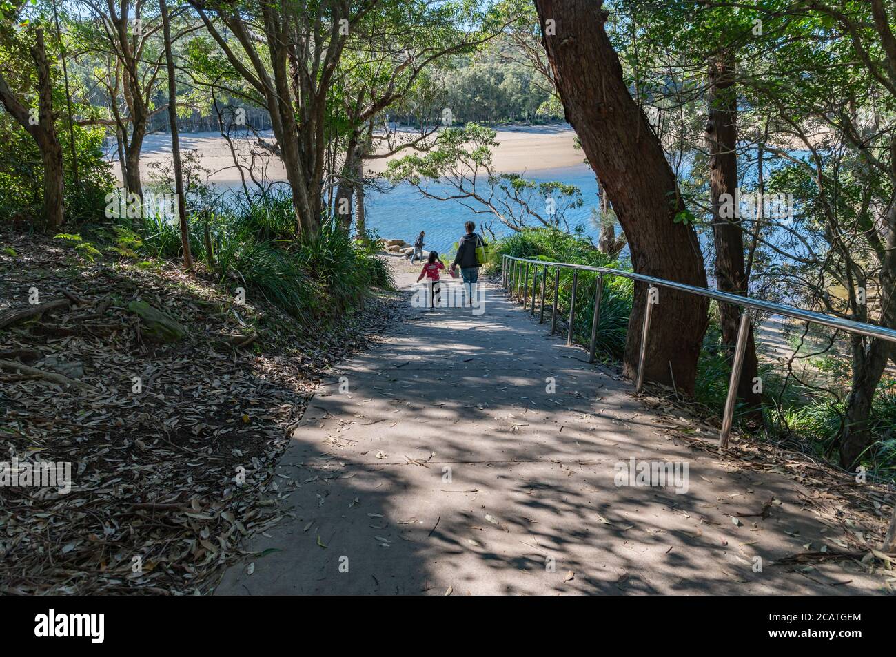 Les gens qui marchent sur le sentier vers Coote Creek et Blue Eaux contexte à la plage de Wattamolla lors d'un après-midi d'hiver ensoleillé Banque D'Images