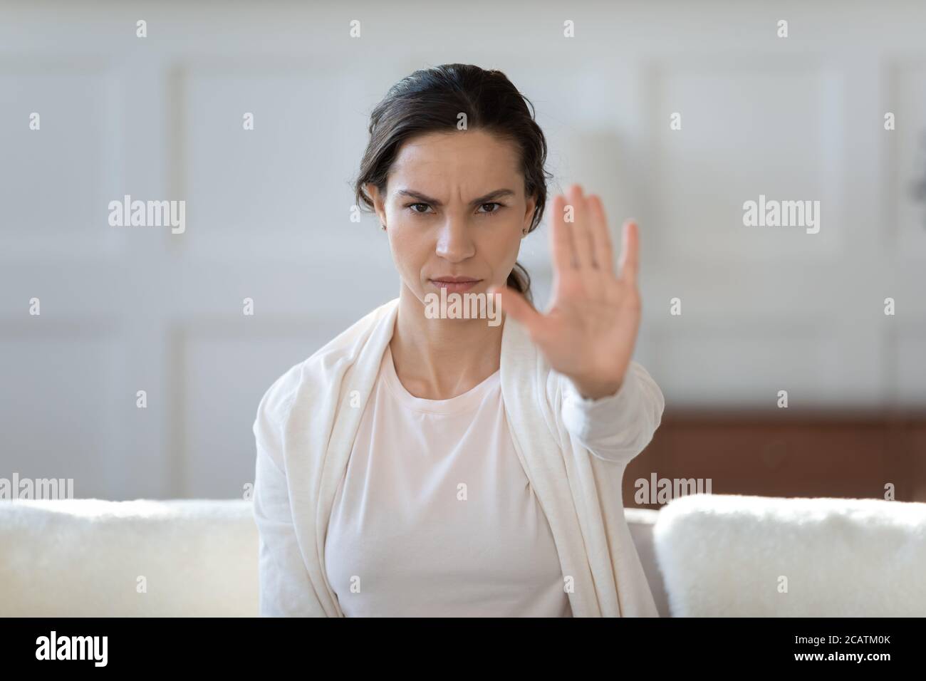 Une jeune fille sérieuse et confiante manifestant un signe contre la violence domestique. Banque D'Images