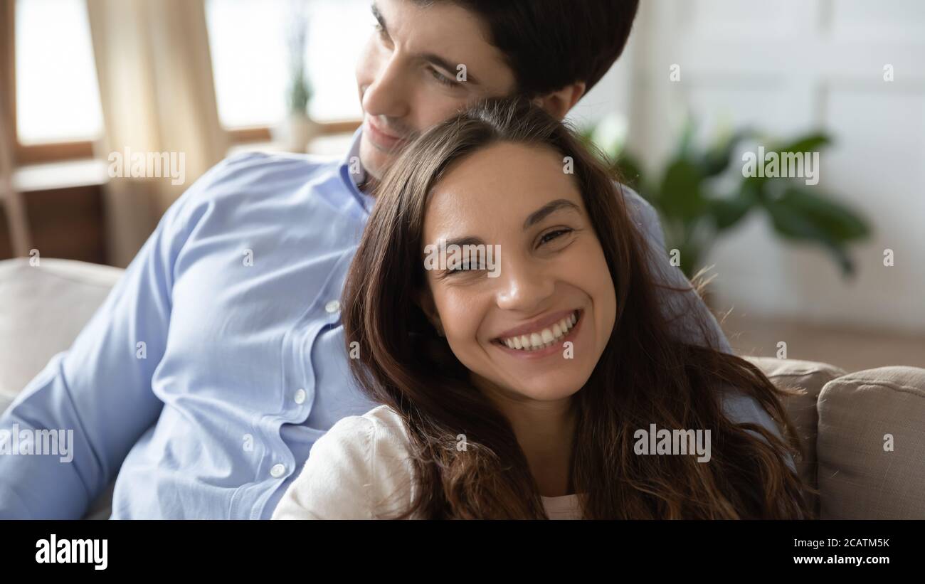 Un jeune couple caucasien souriant profite d'un doux moment à l'intérieur. Banque D'Images