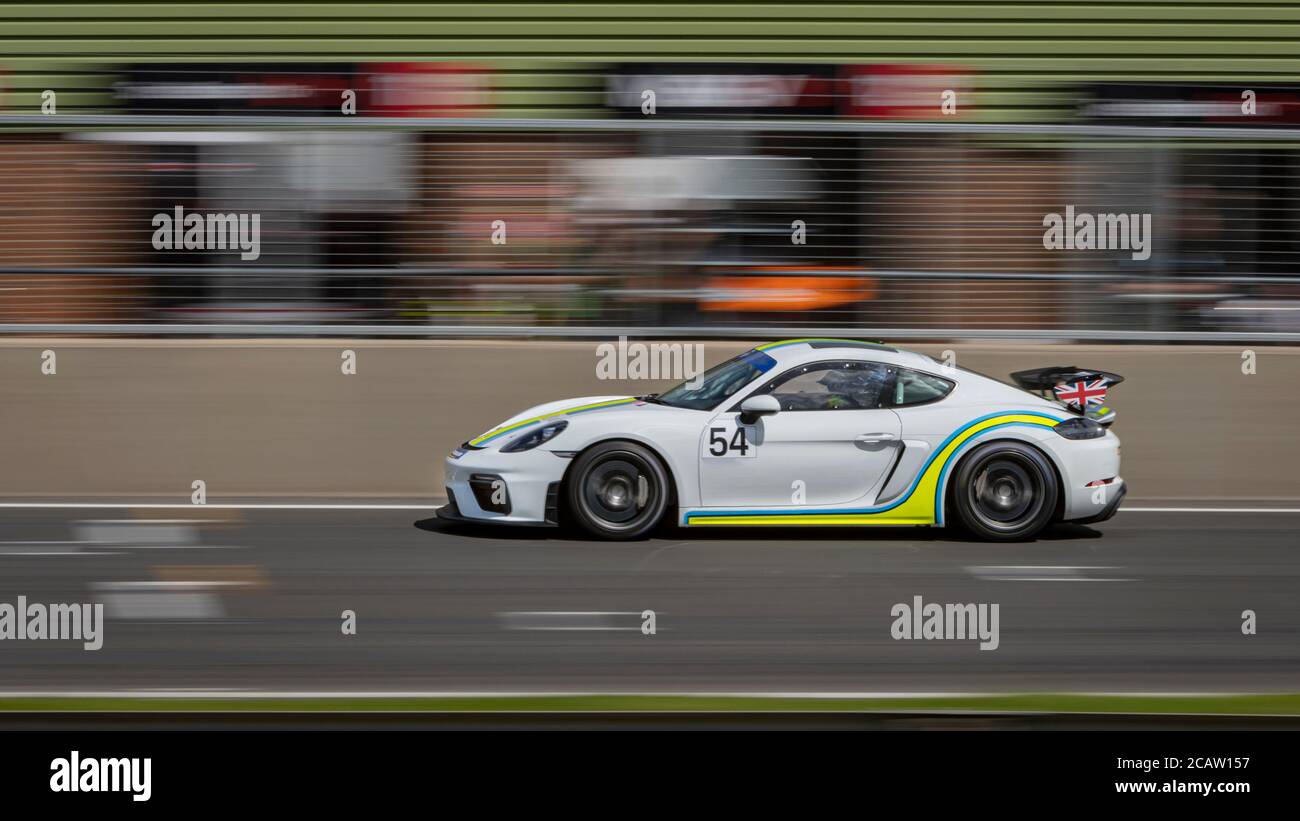 Une photo panoramique d'une voiture de course blanche en circuit sur une piste. Banque D'Images