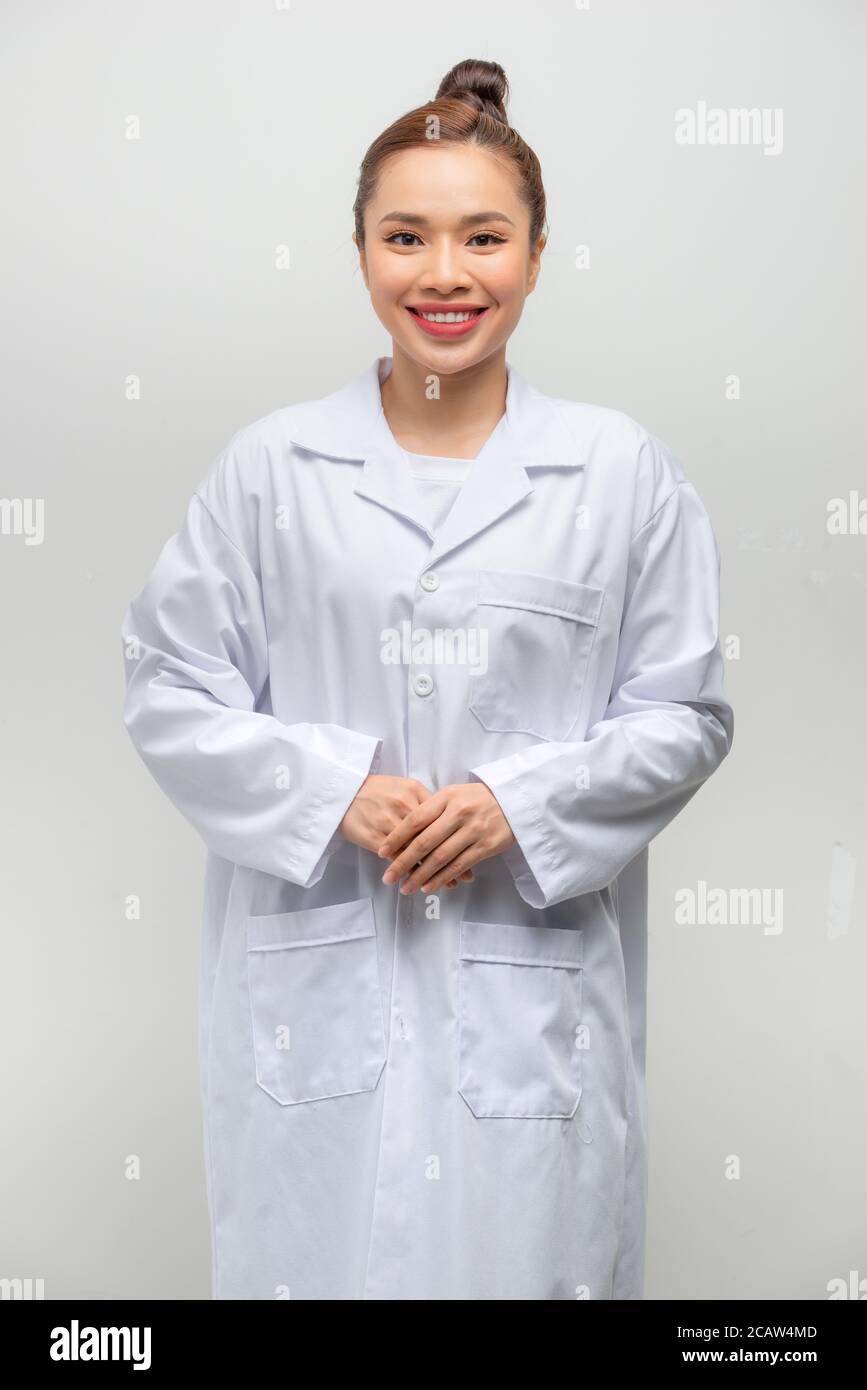 Jeune femme médecin asiatique portant un manteau debout sur un blanc isolé arrière-plan avec un sourire heureux et frais sur le visage Banque D'Images
