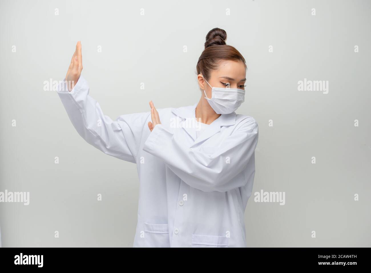 Jeune belle femme médecin portant un manteau peur et terrifié avec l'expression de peur stop geste avec les mains, criant dans le choc. Banque D'Images