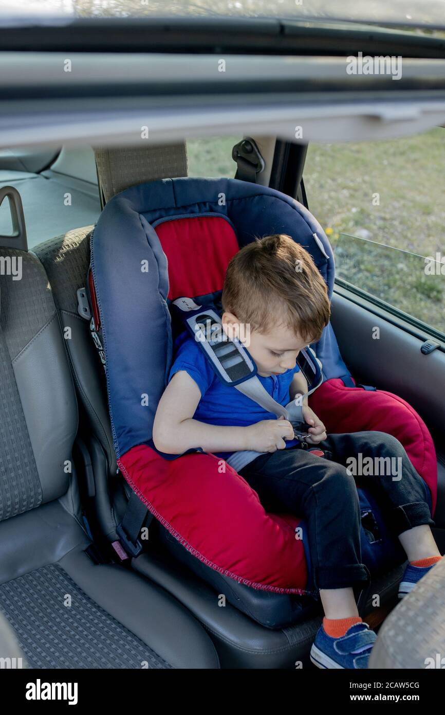 Le petit garçon a bouclé la ceinture de sécurité à l'intérieur de la  voiture. Véhicule et transport Photo Stock - Alamy
