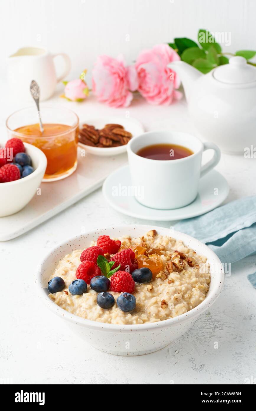 Porridge de flocons d'avoine avec myrtille, framboises, vue latérale, verticale. Petit déjeuner sain avec baies Banque D'Images