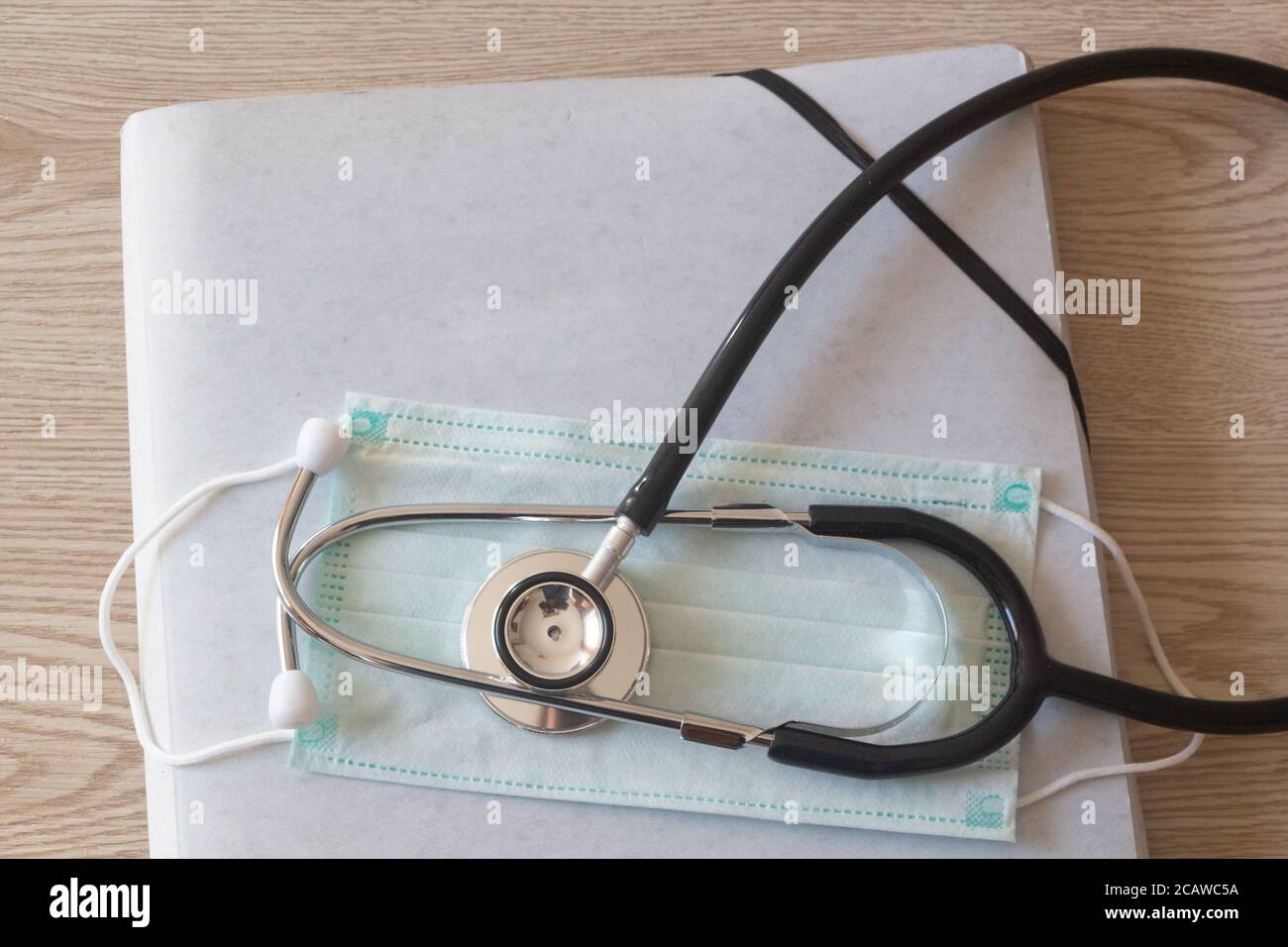 Dossier, masque médical et stéthoscope noir sur fond en bois Banque D'Images