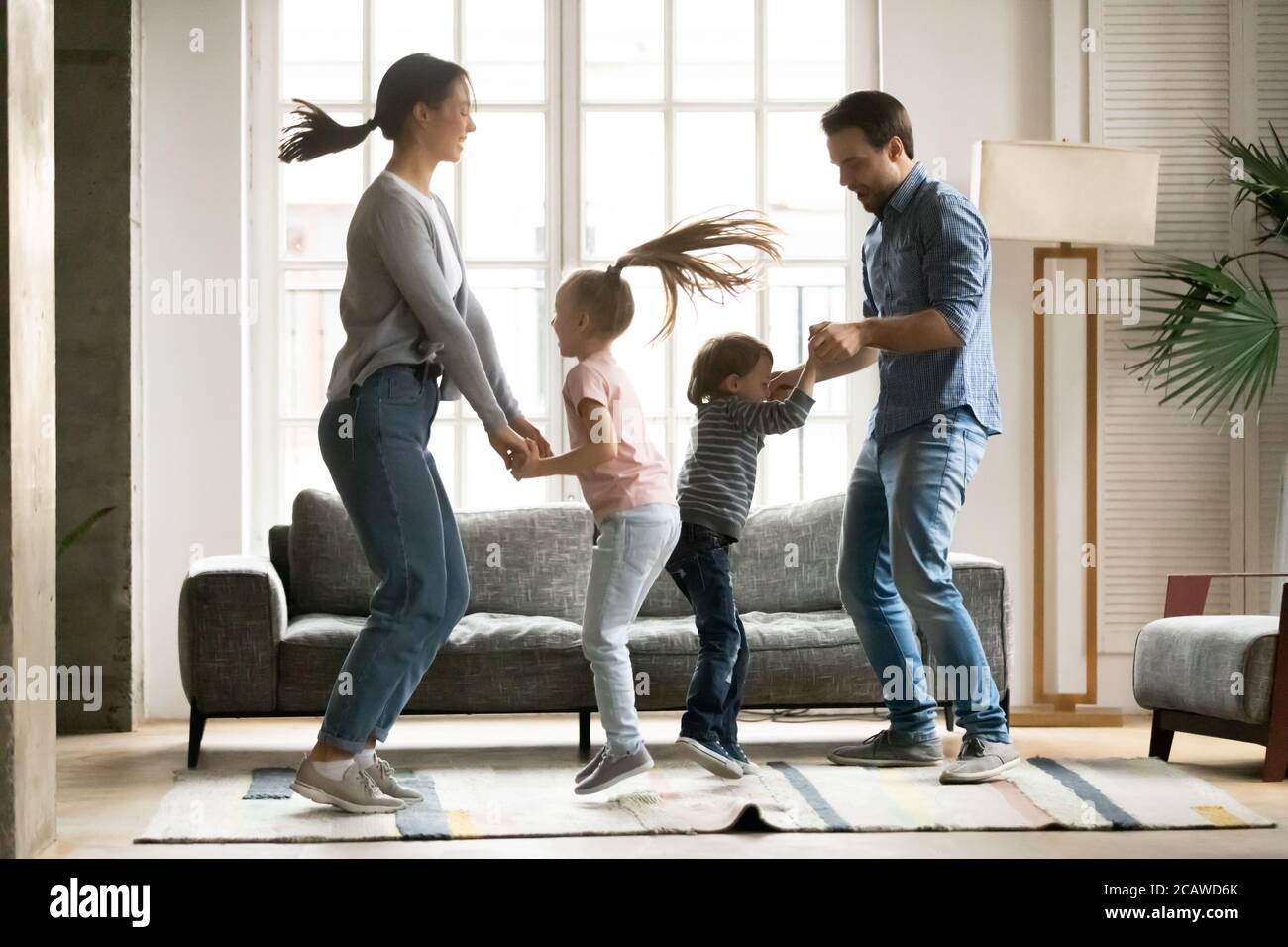 Des jeunes parents énergiques et positifs dansant avec des enfants. Banque D'Images