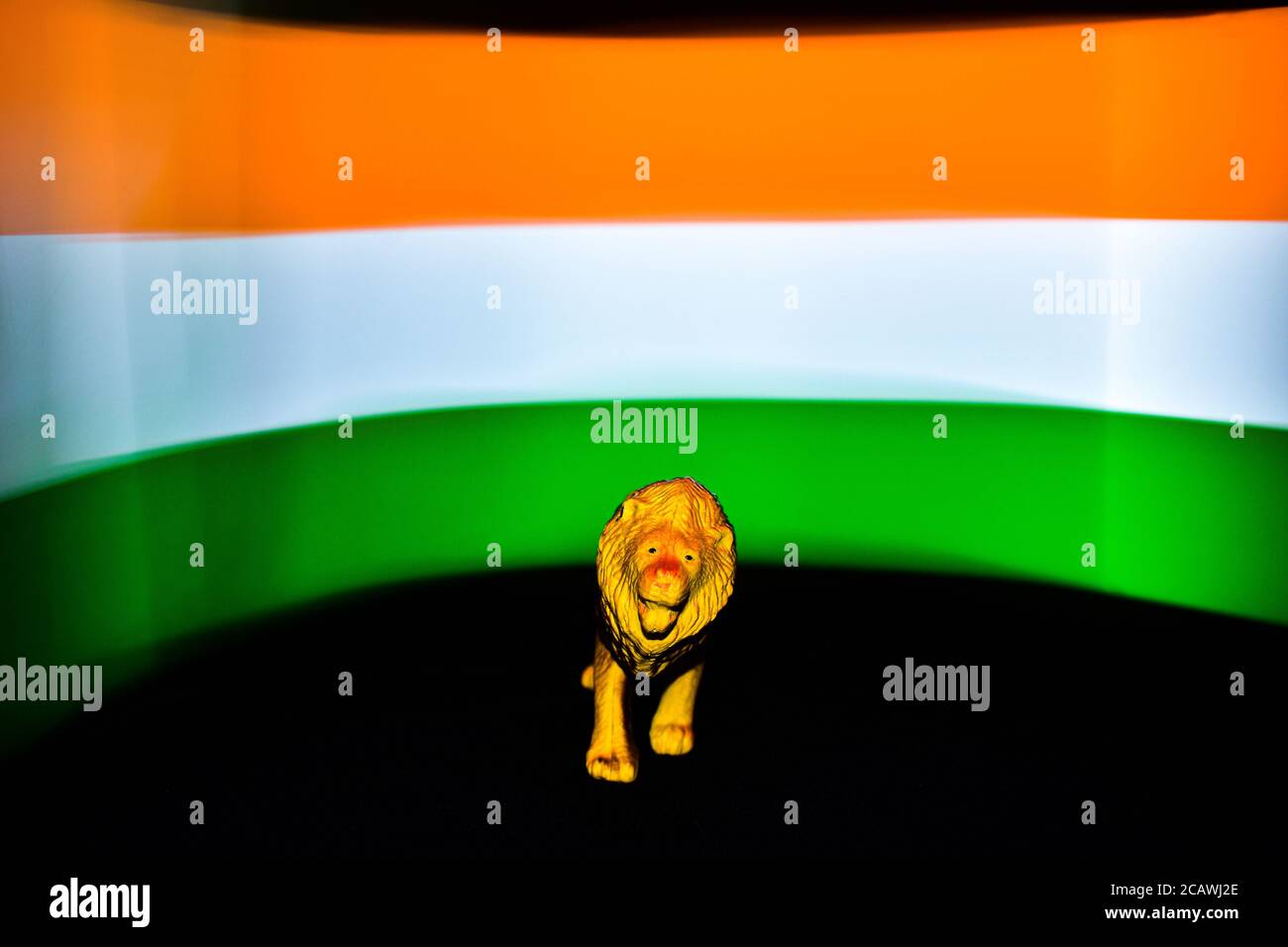 Un lion devant le drapeau indien dans le Arrière-plan avec sol noir. Photographie de drapeau en exposition longue Banque D'Images