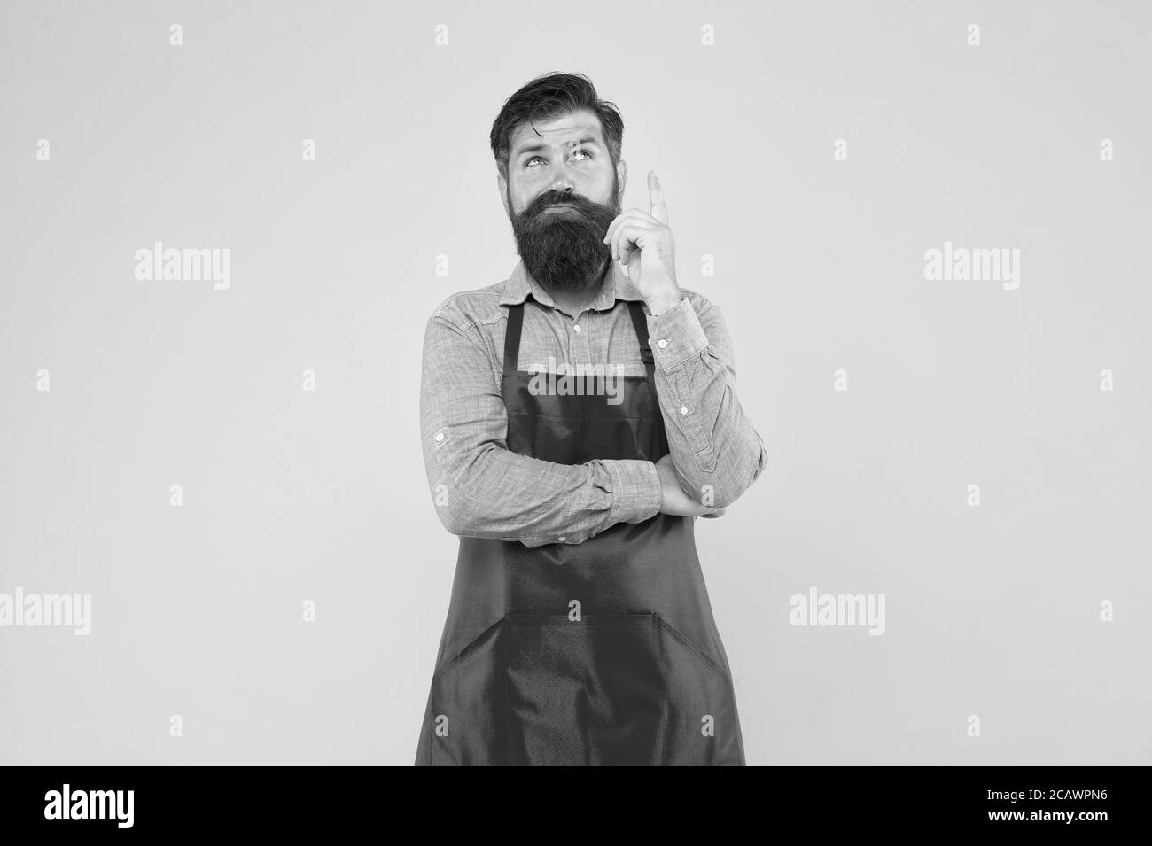 Hipster dans le tablier en pensant aux recettes. Recettes faciles à cuisiner. Recettes saines uniques. Planifiez des repas hebdomadaires. Contrôle de cuisson chaque repas que vous faites. Prenez des décisions saines lors de la commande de nourriture au restaurant. Banque D'Images