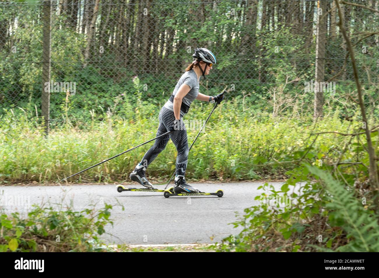 Femme ski à roulettes sur une route tranquille, Aldershot, Royaume-Uni Banque D'Images