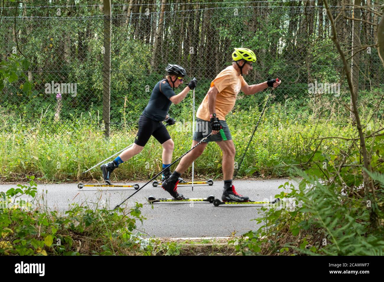 Deux hommes ski à roulettes sur une route tranquille, Aldershot, Royaume-Uni Banque D'Images