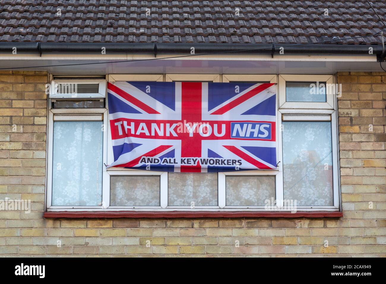 Un drapeau de prise Union à l'avant d'une maison Avec Merci NHS a écrit à ce sujet pendant la pandémie de coronavirus Au Royaume-Uni Banque D'Images