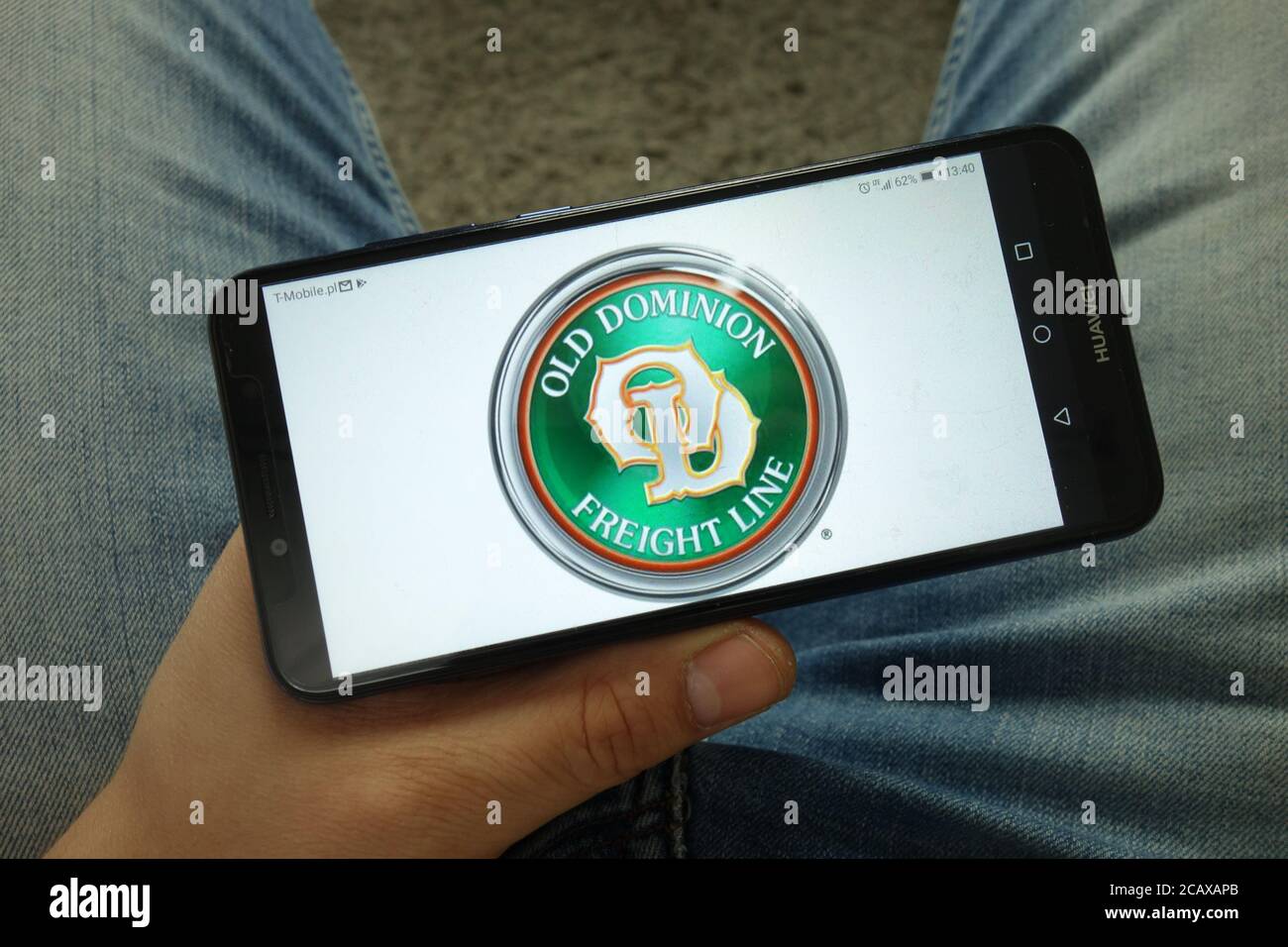 Homme tenant un smartphone avec le logo de la compagnie Old Dominion Freight Line Banque D'Images Homme tenant un smartphone avec le logo de la compagnie Old Dominion Freight Line Banque D'Images