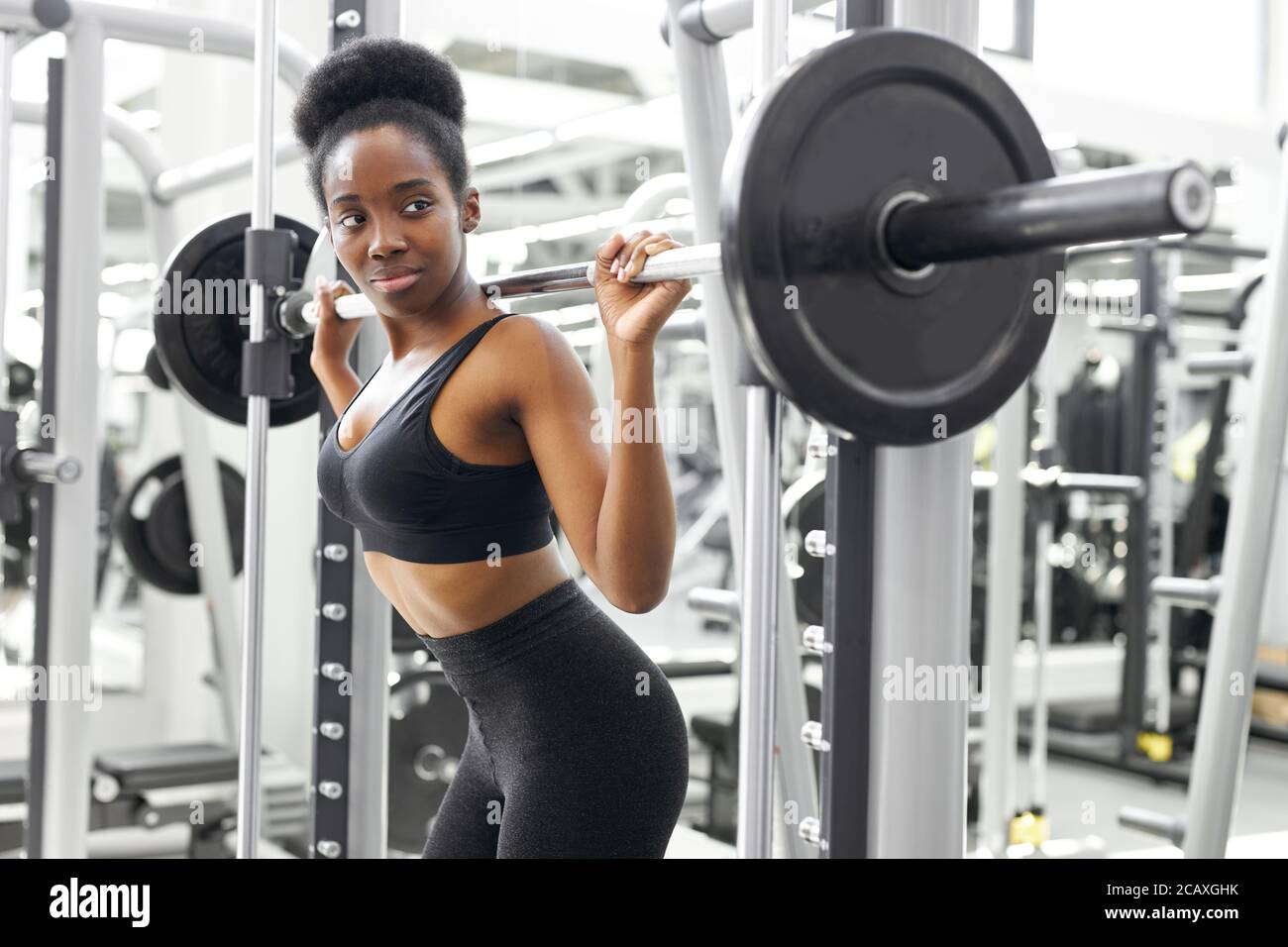musclé africaine forte femme levant lourd barbell pompant biceps dans la  salle de musculation Photo Stock - Alamy