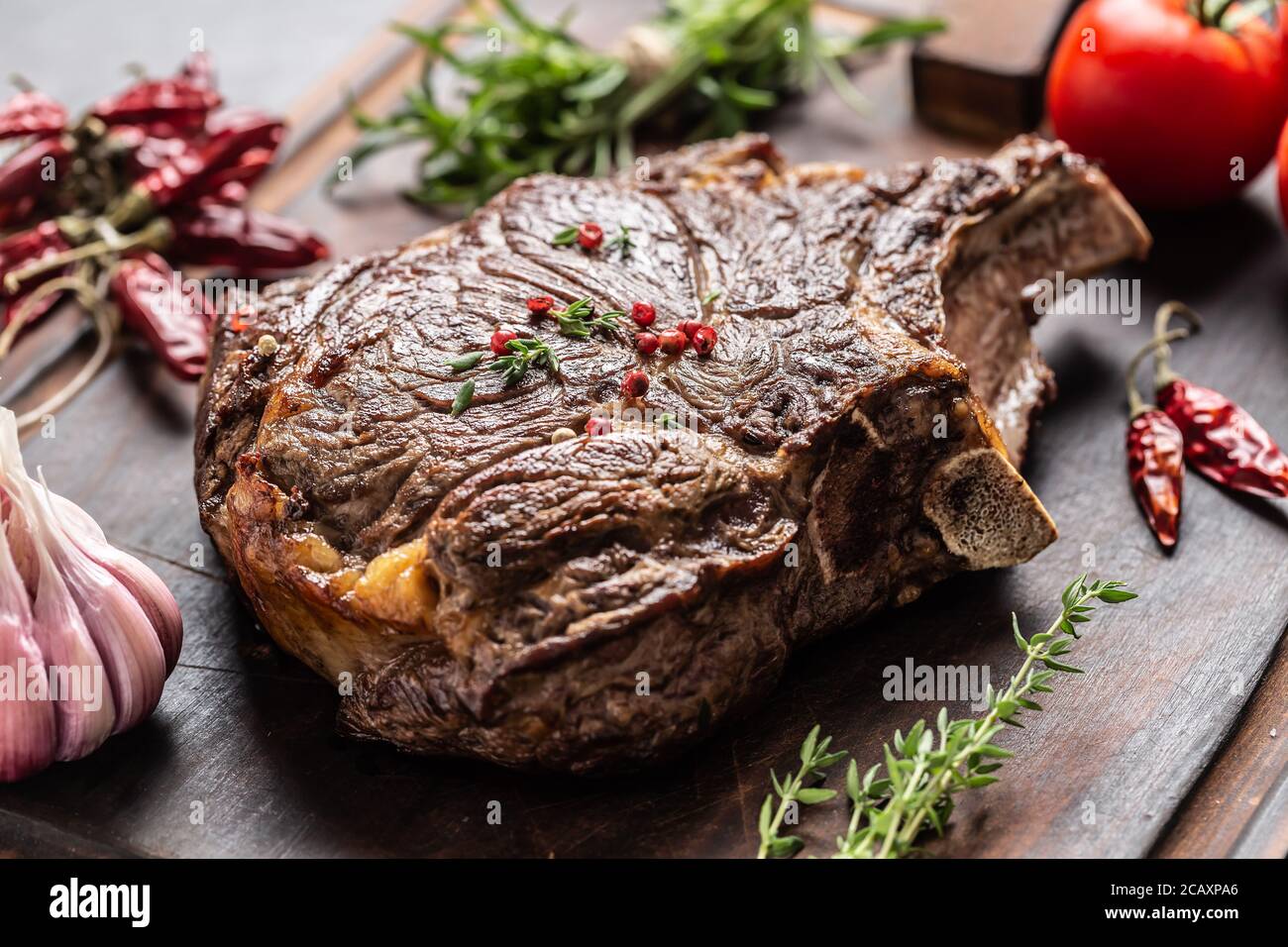 Steak de bœuf grillé aux épices, sel, poivre et ail sur planche à découper en bois Banque D'Images