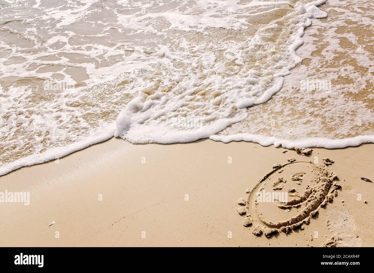 Un visage souriant est dessiné dans le sable de la plage alors que les vagues s'écraseront, le 24 décembre 2012, à Dauphin Island, en Alabama. (Photo de Carmen K. Sisson/Cloudybright) Banque D'Images