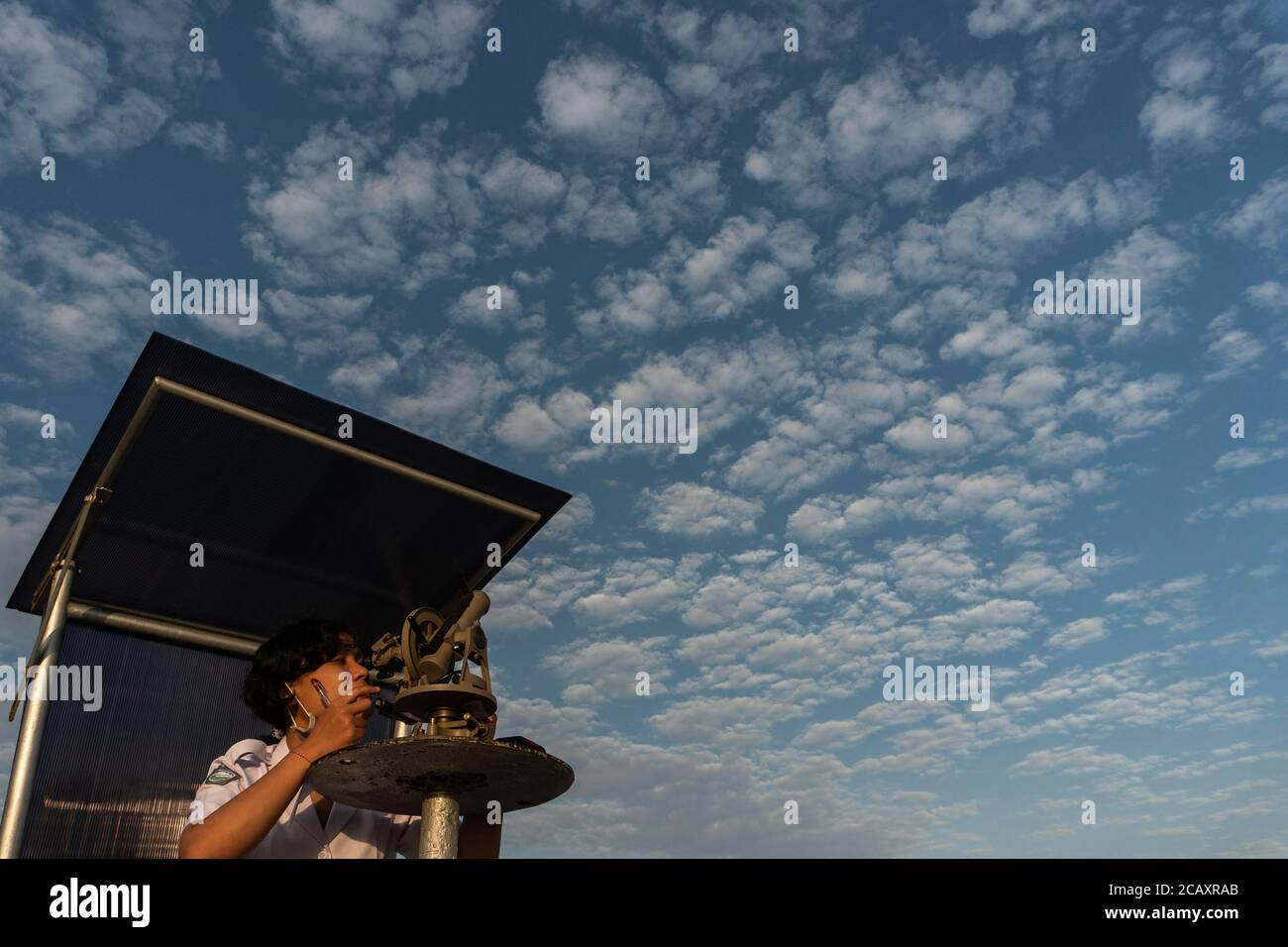 BADUNG/BALI-AOÛT 4 2020 : observateur météorologique ou prévisionniste utilisant une théodolite pour l'observation aérienne. Elle fait l'observation de ballon pilote sous le b Banque D'Images