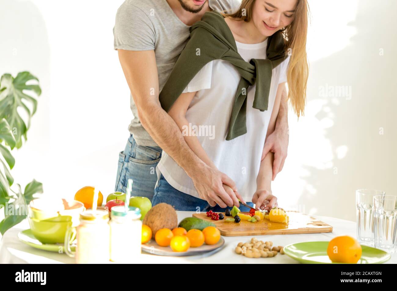 jeune homme et femme en essoré les ingrédients avec beaucoup de soin. photo rognée Banque D'Images