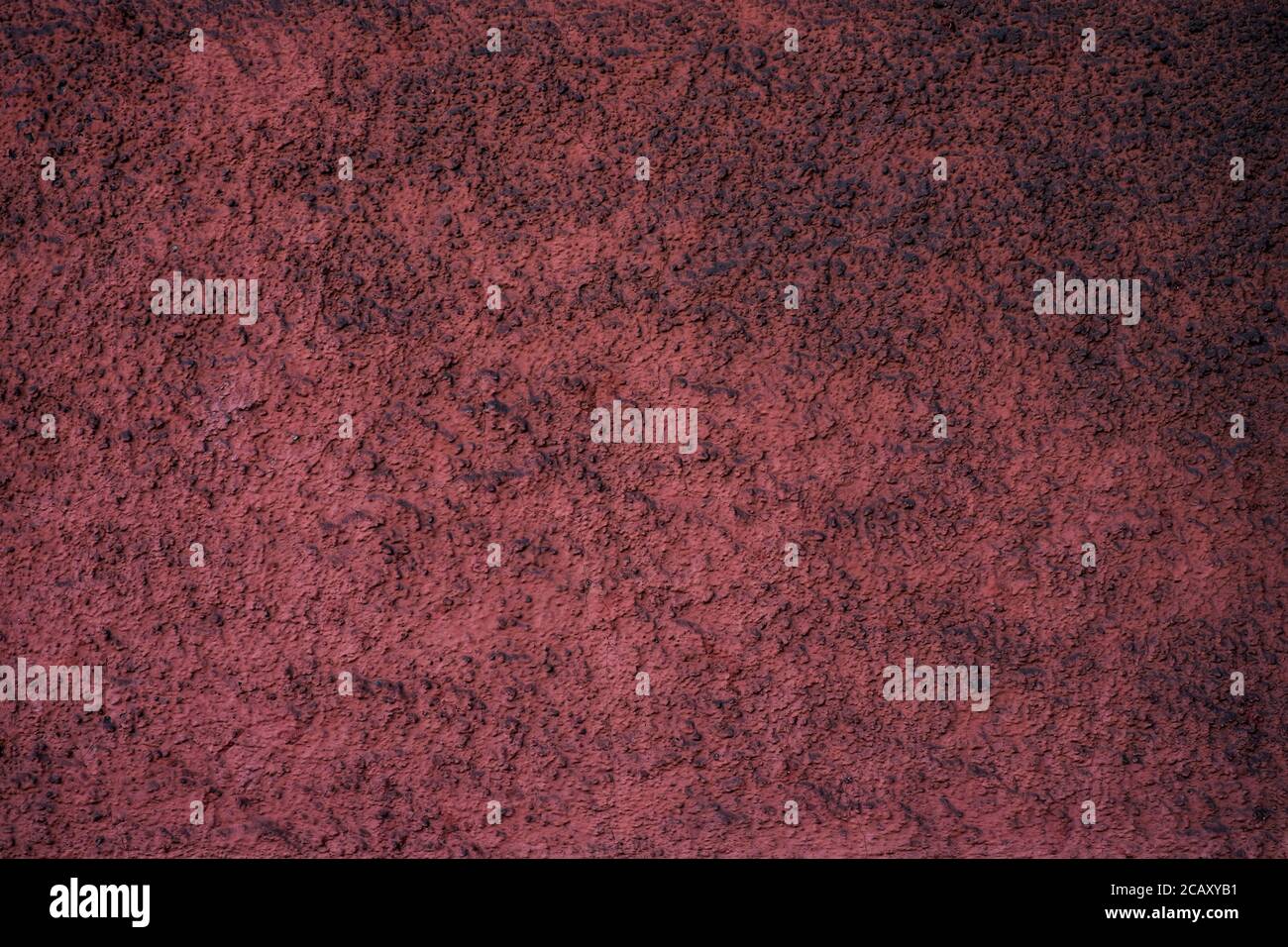 Vider la surface texturée poussiéreuse rouge bordeaux. Banque D'Images