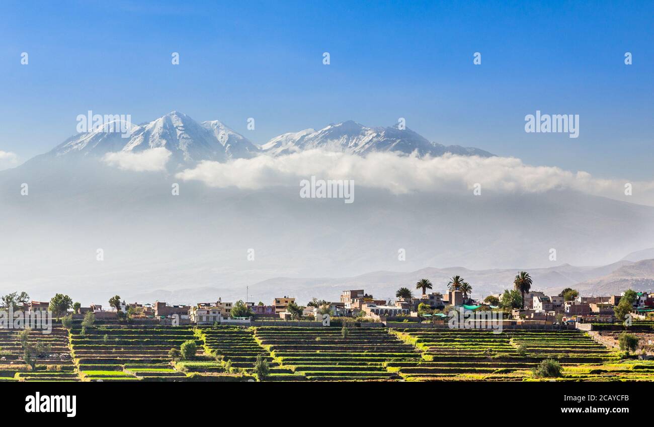 Capes de neige du volcan chachani sur les champs et les maisons de la ville péruvienne d'Arequipa, Pérou Banque D'Images