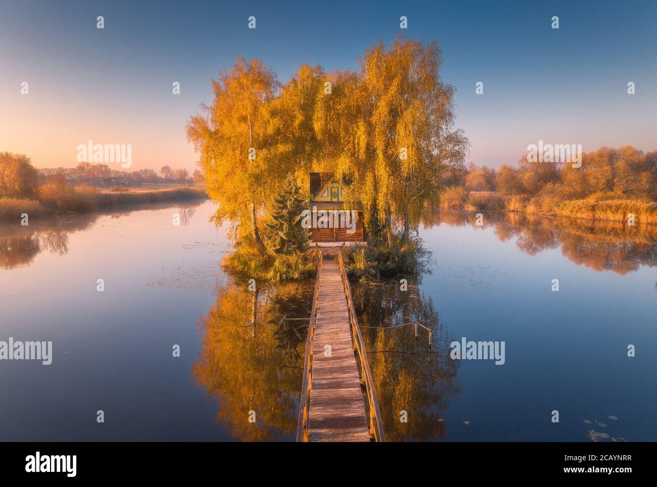 Ancienne maison de pêcheur et jetée en bois au lever du soleil en automne Banque D'Images