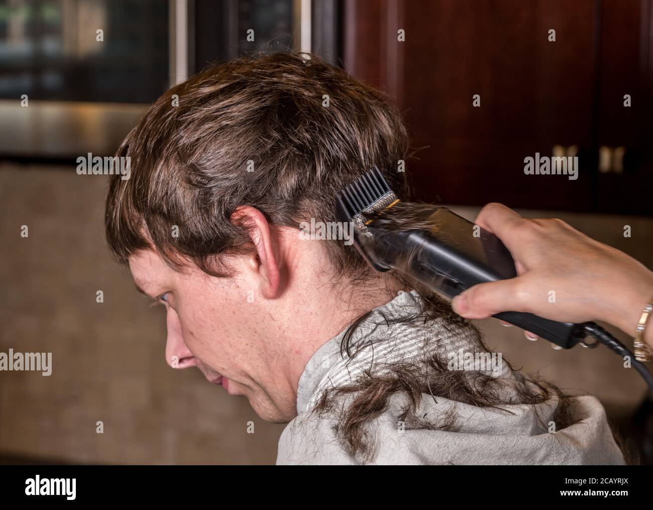 Gros plan de l'homme caucasien ayant ses cheveux coupés à la maison pendant la quarantaine pour le coronavirus. Utilisation de la tondeuse électrique Banque D'Images