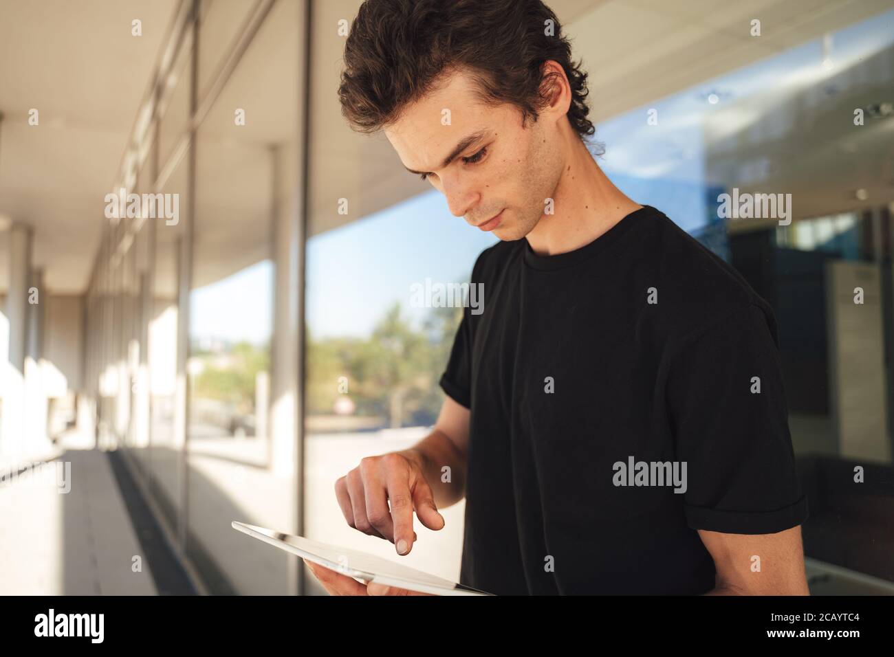 Beau homme de race blanche utilisant une tablette numérique pendant qu'il est à l'université campus Banque D'Images