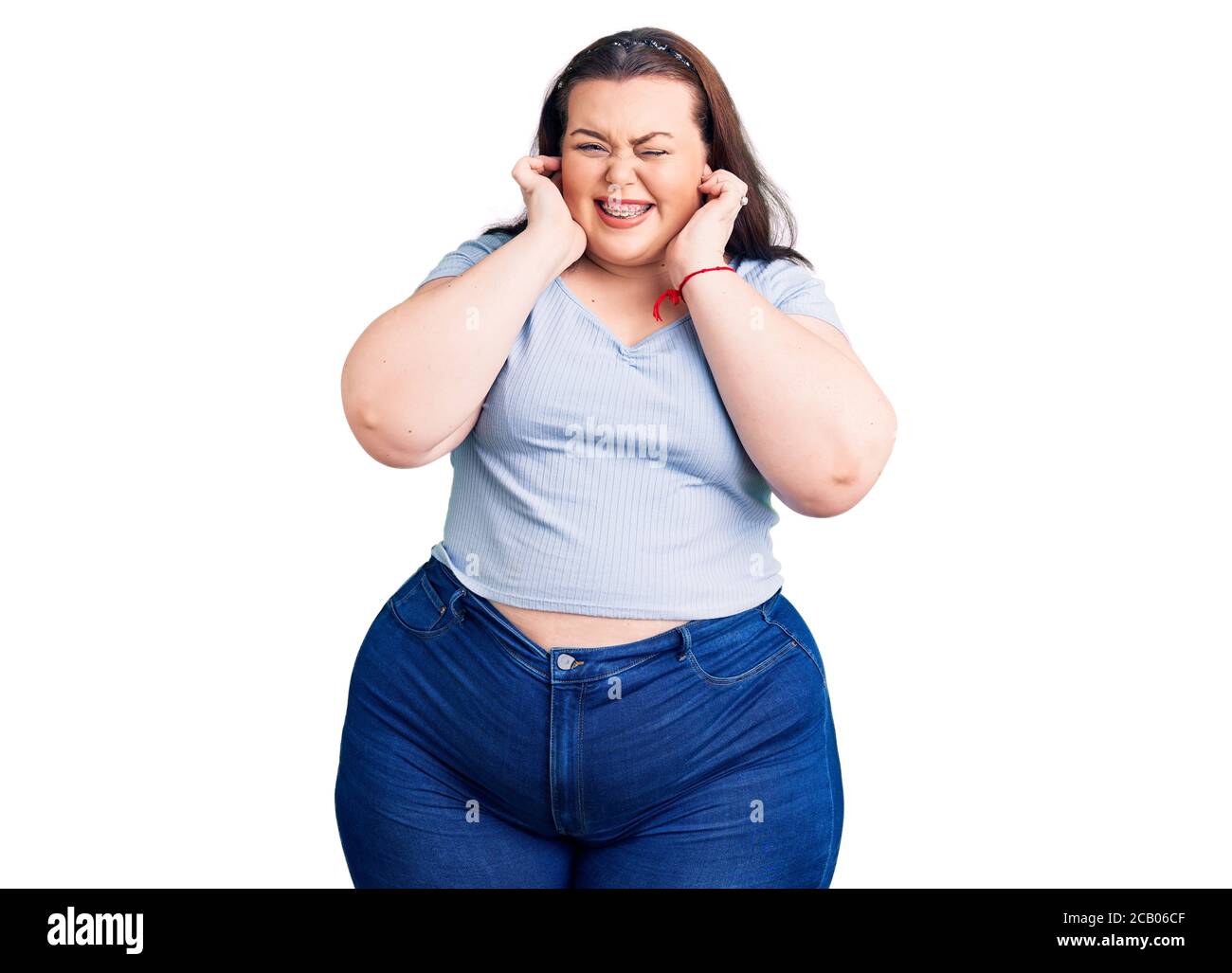 Jeune femme de taille plus portant des vêtements décontractés couvrant les  oreilles avec les doigts avec l'expression agacée pour le bruit de la  musique forte. Concept sourd Photo Stock - Alamy