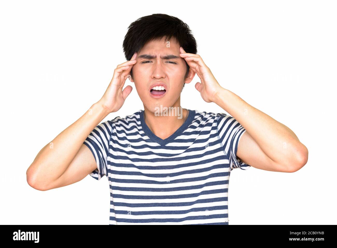 Studio de prise de vue d'un jeune homme asiatique souffrant de maux de tête et regardant à la caméra isolée sur fond blanc Banque D'Images
