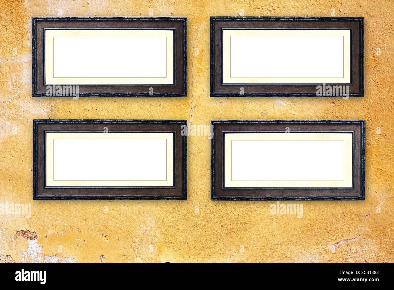 Quatre cadres en bois d'époque vides sur un vieux mur en stuc. Cadre rétro vierge sur le mur de la salle. Modèle de maquette. Copier l'espace pour le texte Banque D'Images