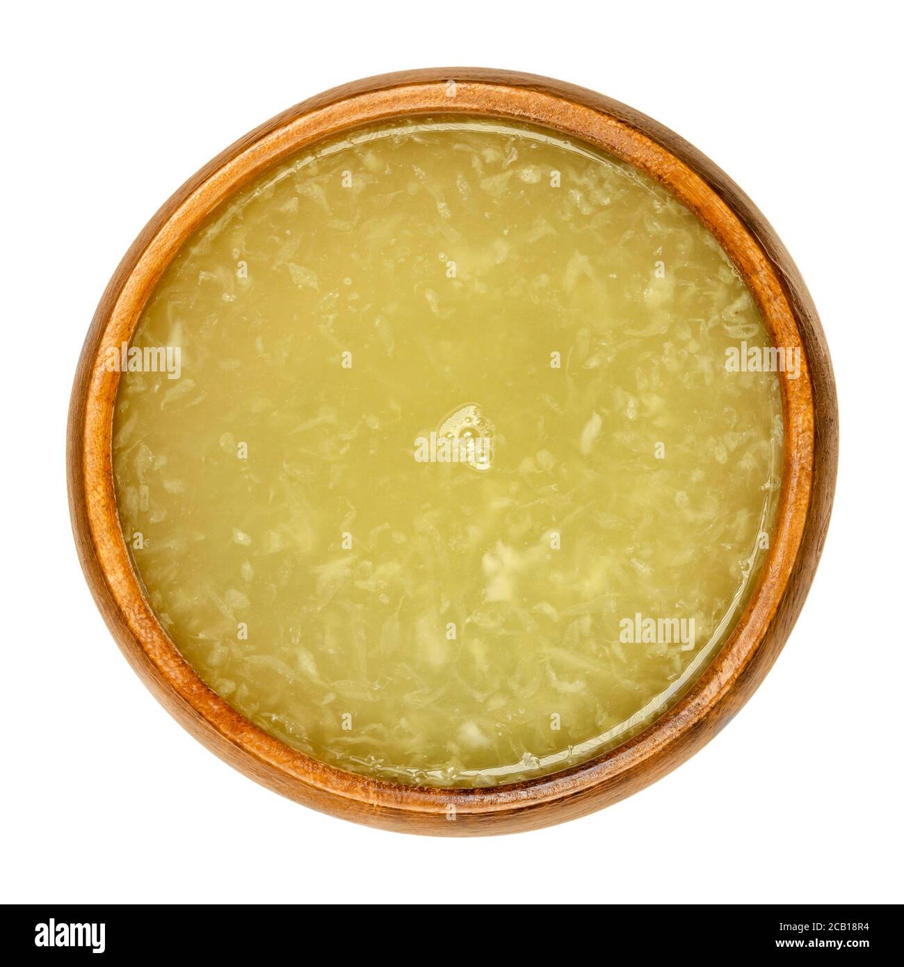 Jus de citron frais dans un bol en bois. Jus de citrons pressés avec pulpe. Agrumes comestibles mûrs, citron limon. À des fins culinaires et de nettoyage. Banque D'Images