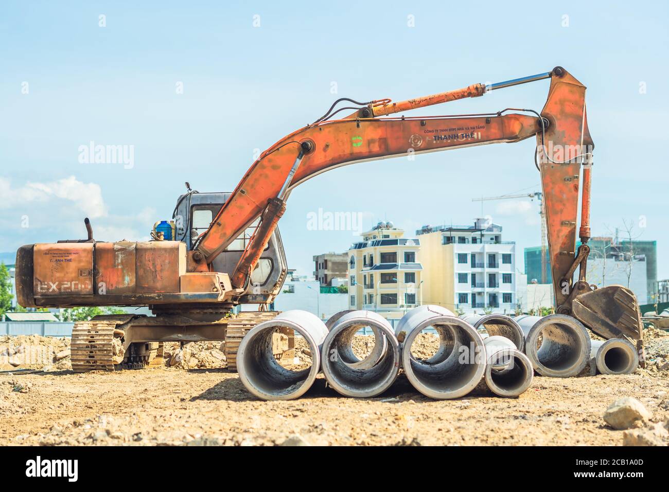 Cheminée de tuyaux de drainage en béton pour puits de rejet d'eau de ponte un système d'égout externe à un chantier de construction et jaune pelle hydraulique digger Banque D'Images