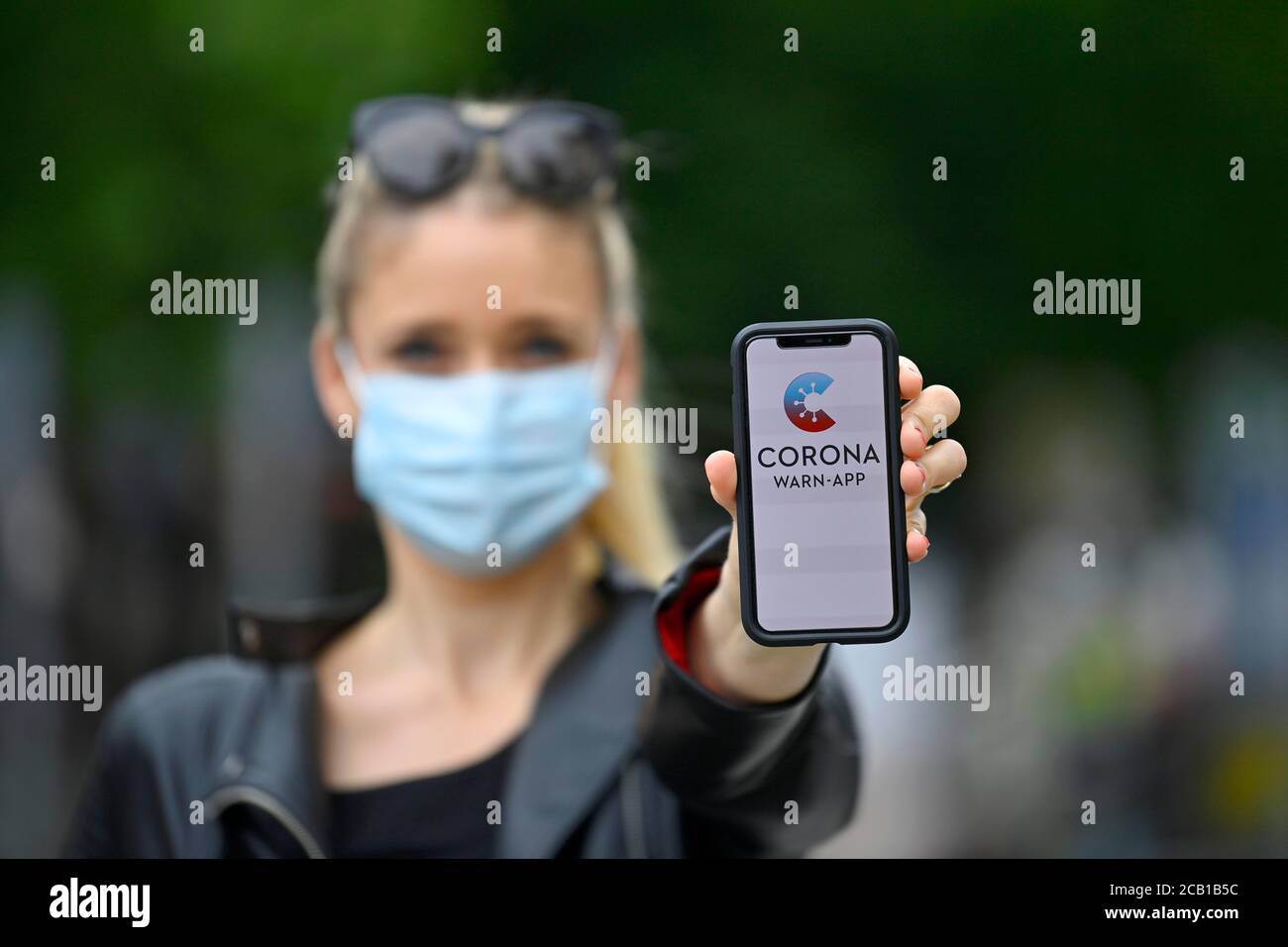 Femme avec masque de visage, montrant smartphone avec Corona warn-APP, crise de Corona, Bade-Wurtemberg, Allemagne Banque D'Images
