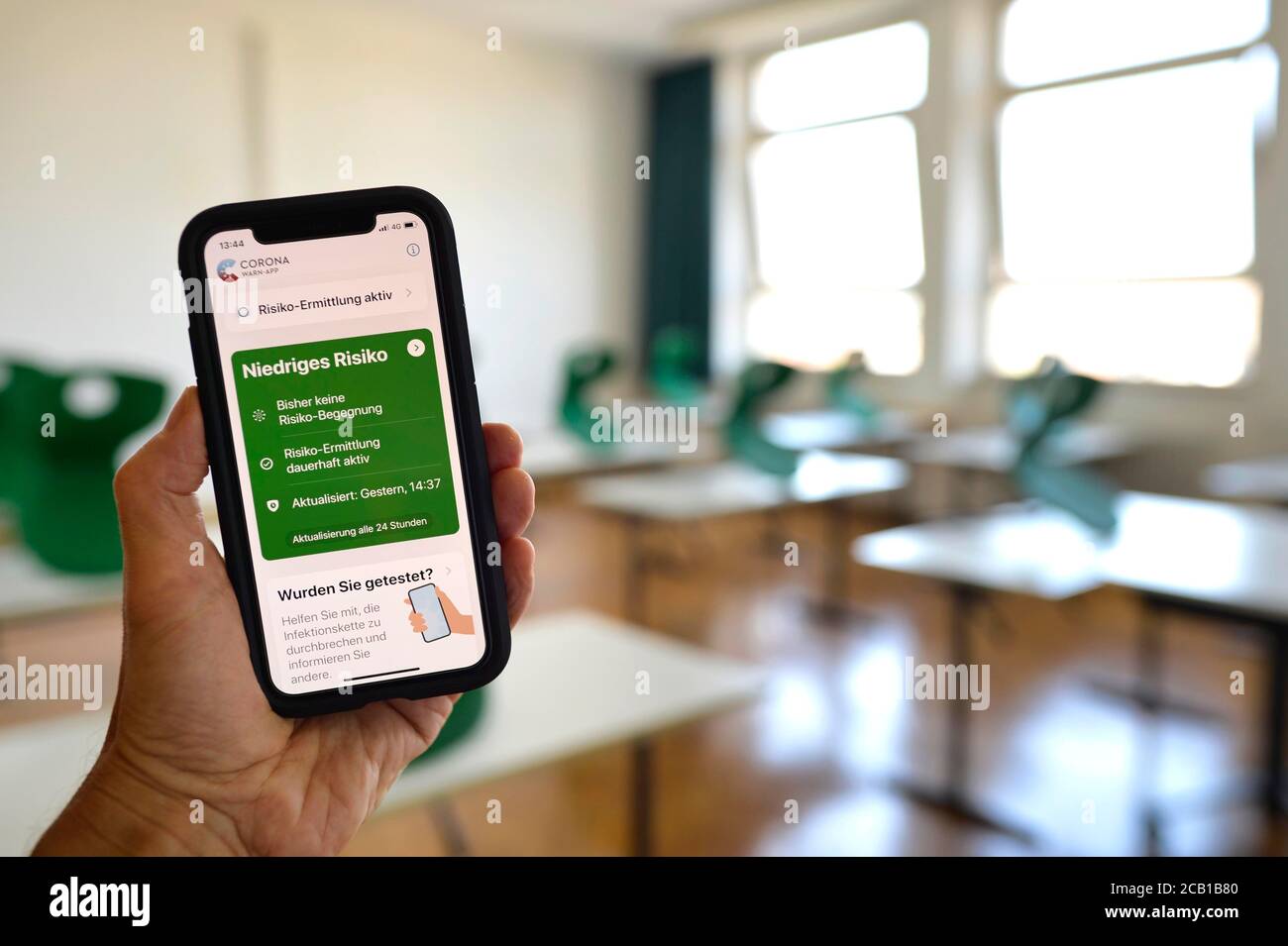 Main tenant un smartphone avec l'application Corona Warning dans la salle de classe, Corona Crisis, Allemagne Banque D'Images