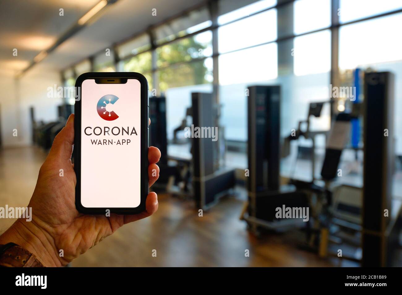 Main tient un smartphone avec Corona warn-APP dans le centre de fitness, Corona Crisis, Stuttgart, Bade-Wurtemberg, Allemagne Banque D'Images