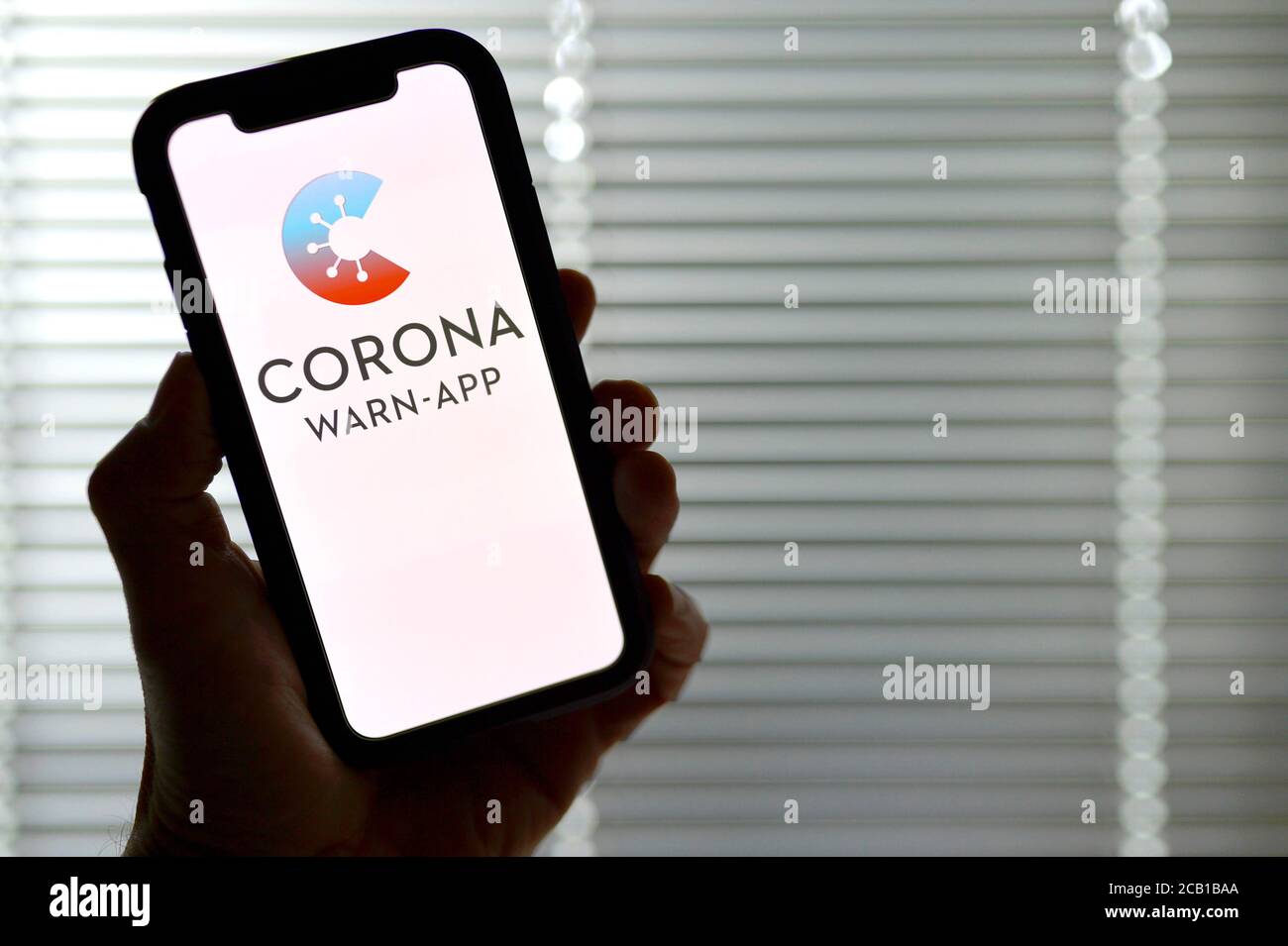 Main tient un smartphone avec Corona warn-APP, Corona Crisis, Allemagne Banque D'Images