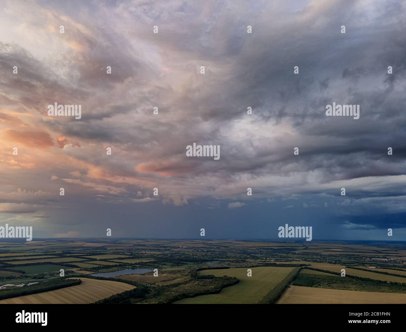 Nuages de pluie sur les champs verts et les lacs. Photo aérienne. Banque D'Images