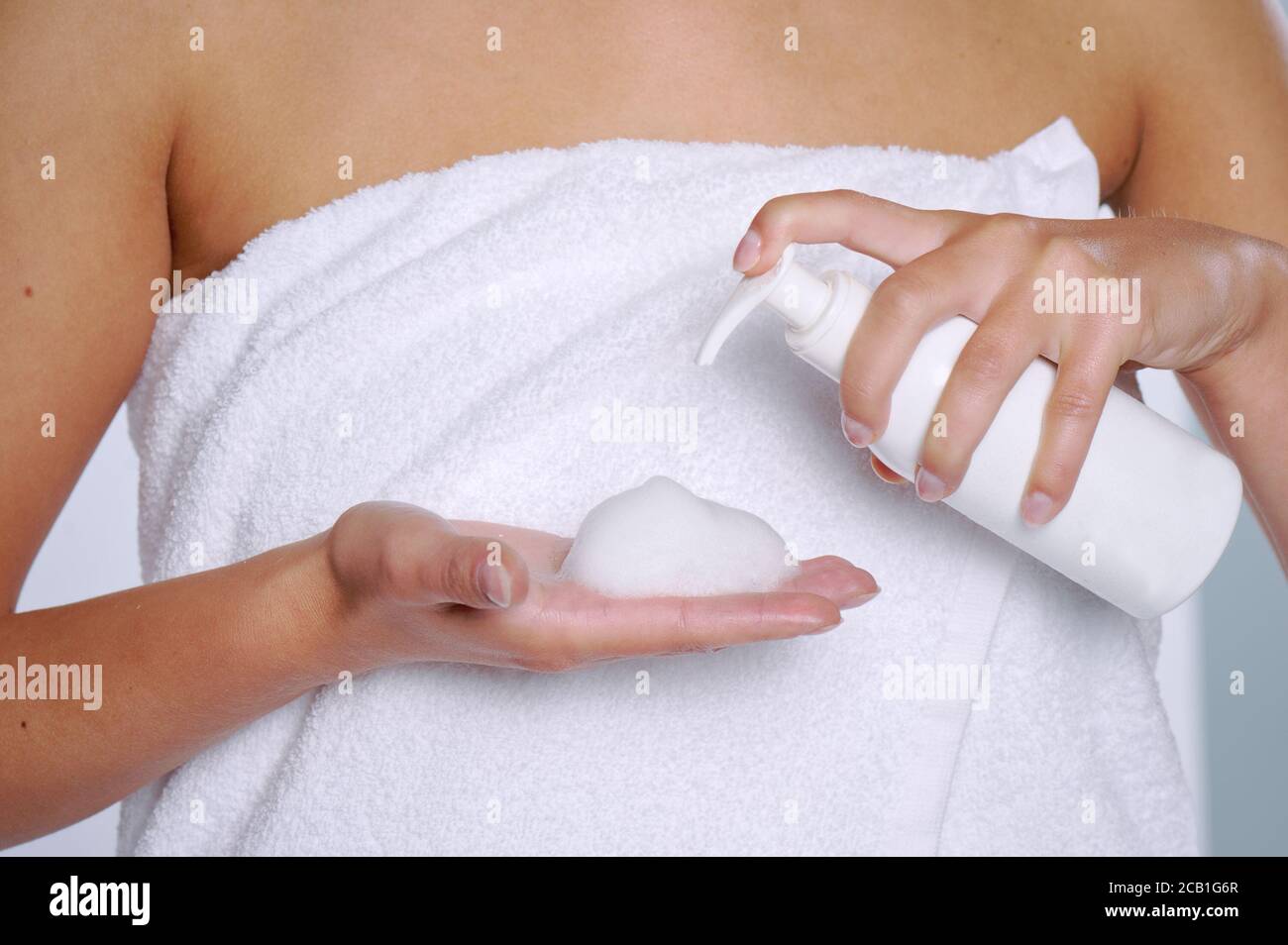 Femme pressant le savon liquide à sa main. Flacon de savon blanc avec distributeur à la main. Banque D'Images