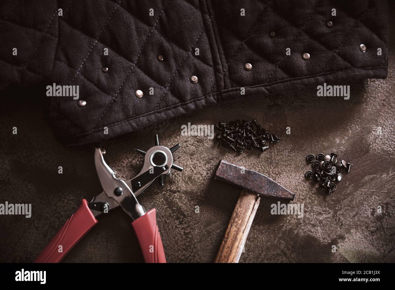 beaucoup d'outils comme un cuir de poinçon ou un marteau et quelques rivets  de cuivre, la fabrication d'équipement de maroquinerie sur un backgound  brun Photo Stock - Alamy