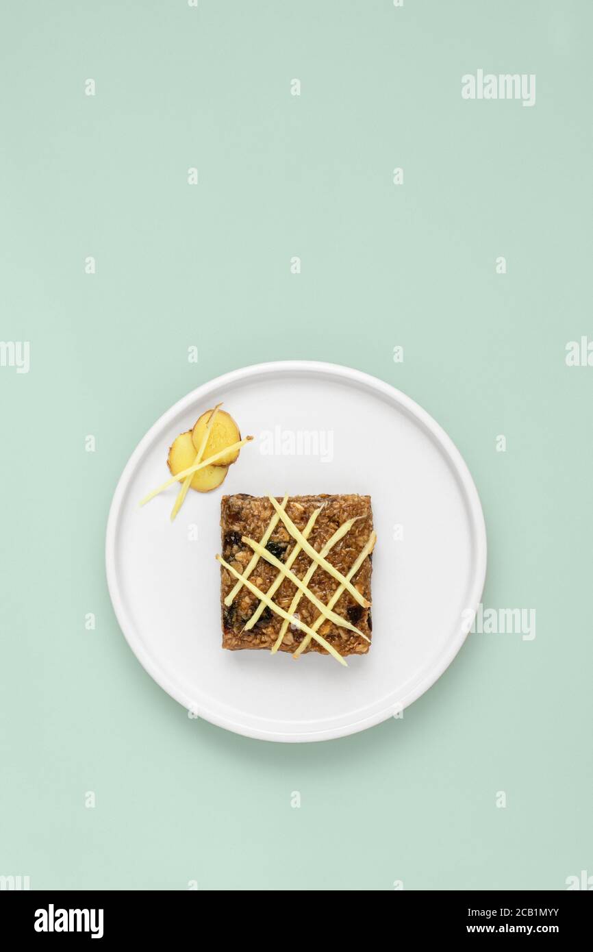 Flapjack au gingembre recouvert de gingembre râpé sur une assiette blanche Banque D'Images