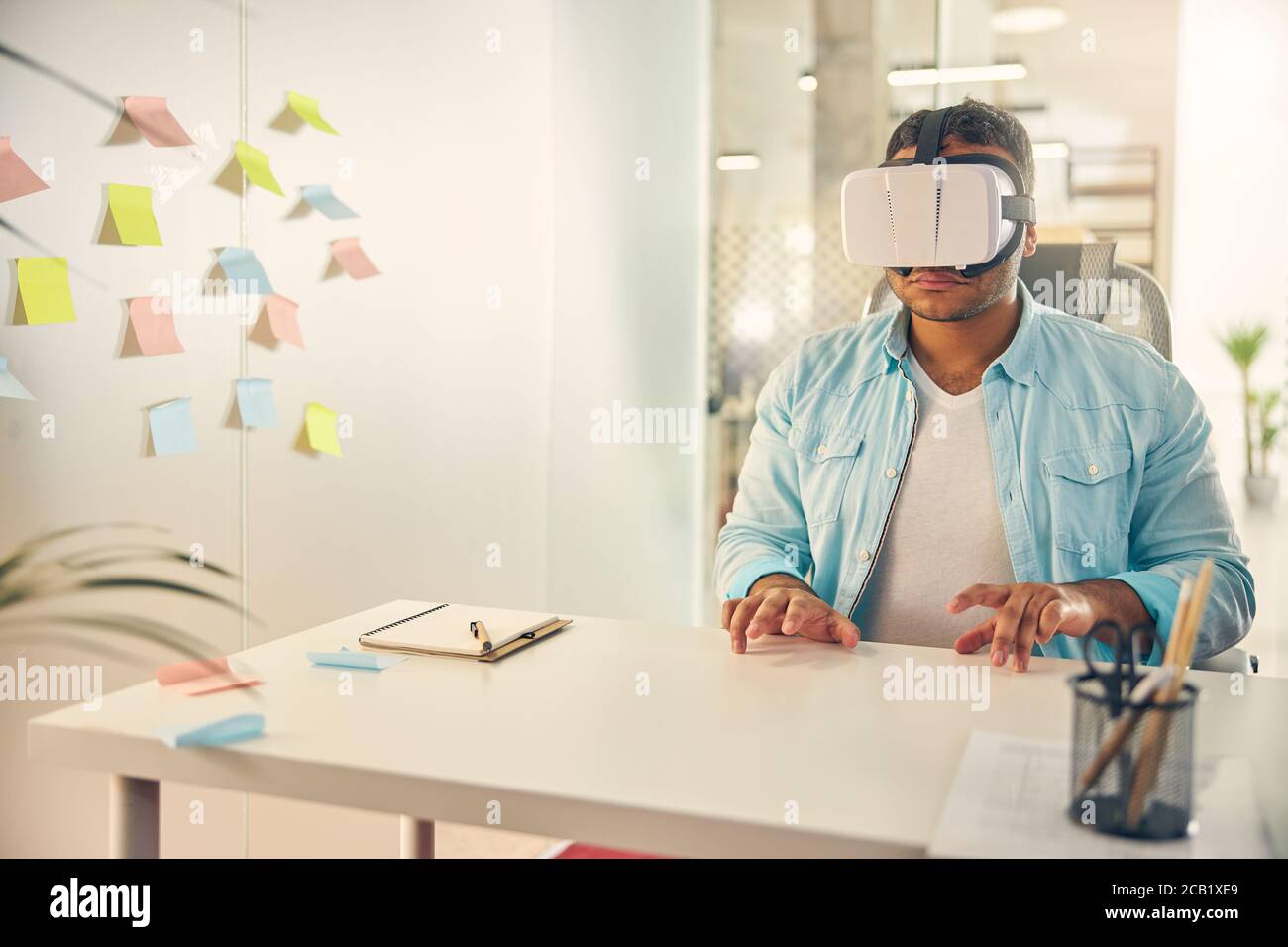 Un jeune employé de bureau frustré teste la vision virtuelle Banque D'Images