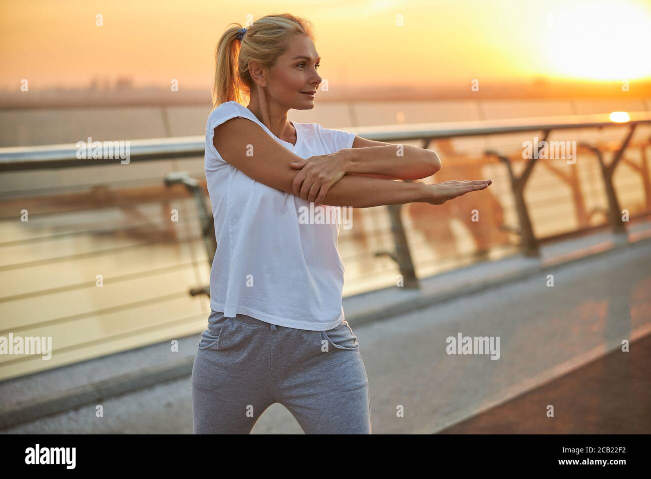 Femme en sport faisant un exercice d'échauffement Banque D'Images
